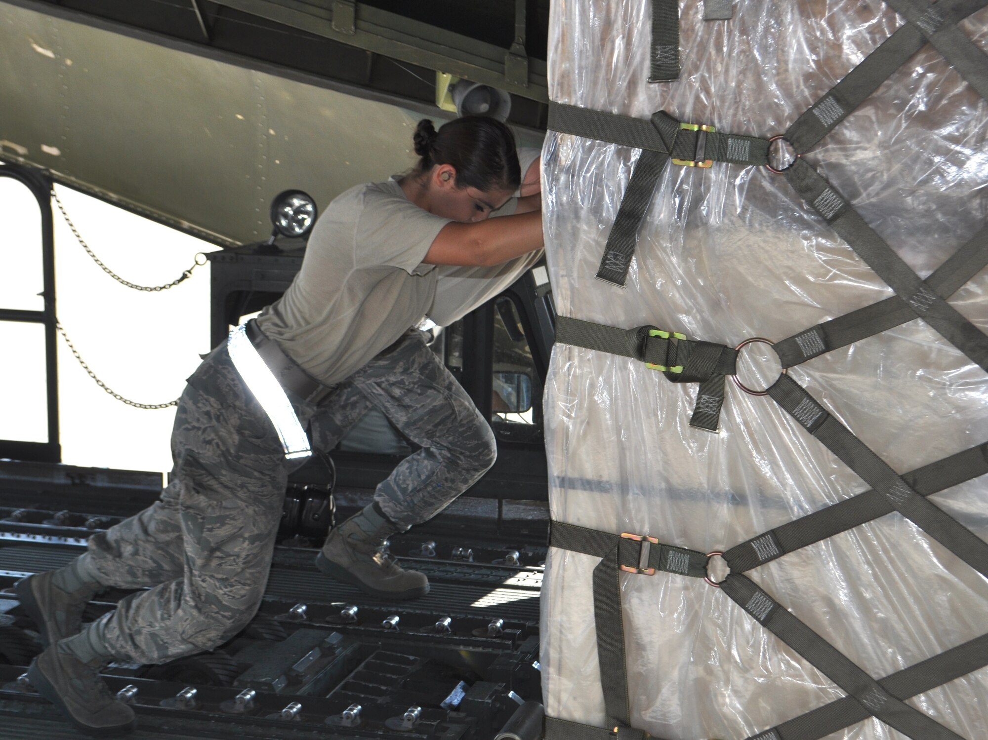 TRAVIS AIR FORCE BASE, Calif. -- Airman 1st Class Jessica Cummings and Reese Sparacino push a full pallet onto a Westover ARB C-5, on the Travis AFB flight line. They were part of a team completing a 36-pallet load on this, and another C-5 assigned to the Reserve wing at Joint Base San Antonio. (U.S. Air Force photo/Ellen Hatfield)