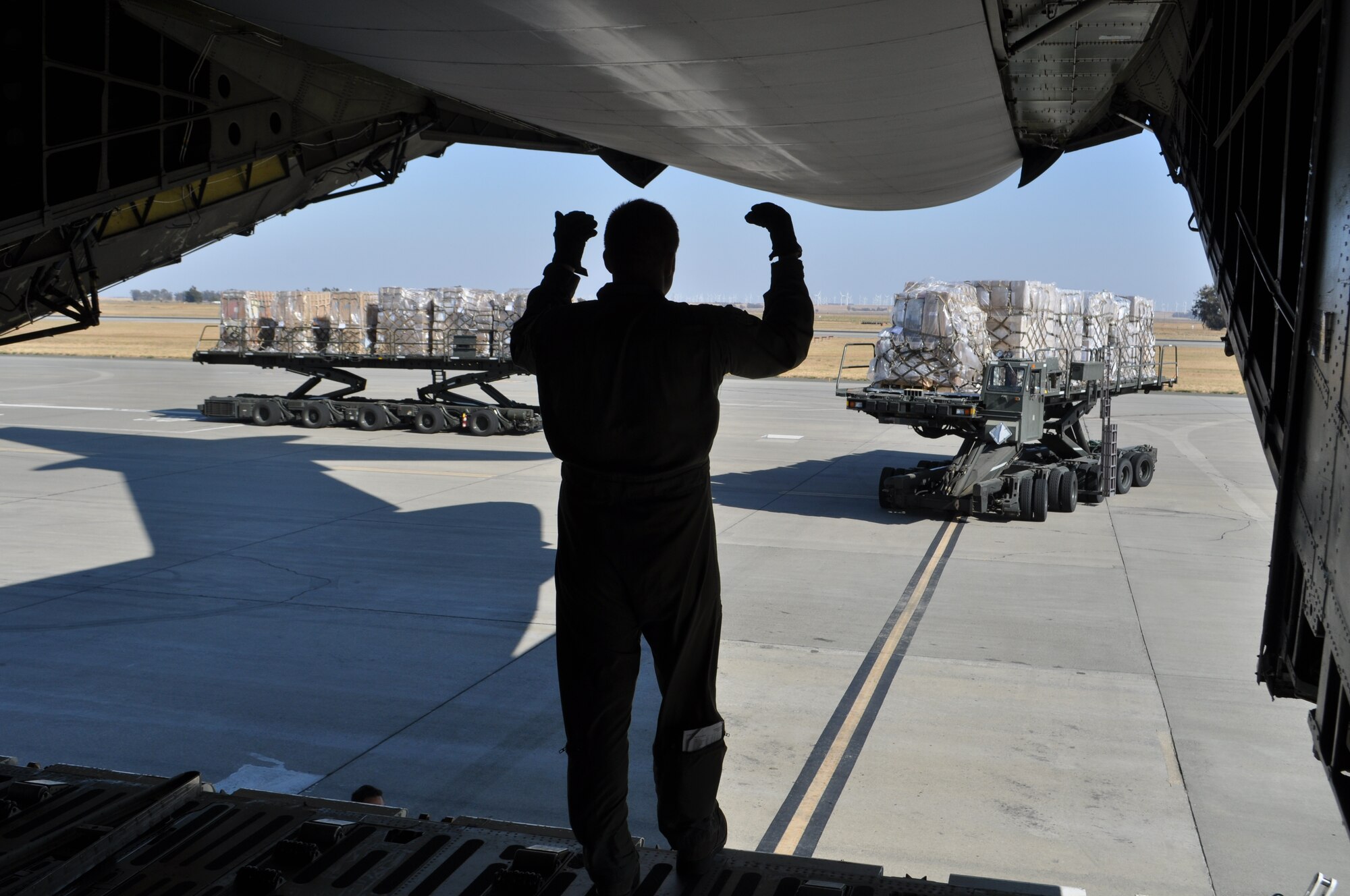 TRAVIS AIR FORCE BASE, Calif. -- Tech. Sgt. Jonathan Ash, a loadmaster with the 439th Airlift Wing, Westover Air Reserve Base, Massachusetts, marshals in a 60K loader for a pallet load on his wing’s C-5, at Travis AFB. (U.S. Air Force photo/Ellen Hatfield)