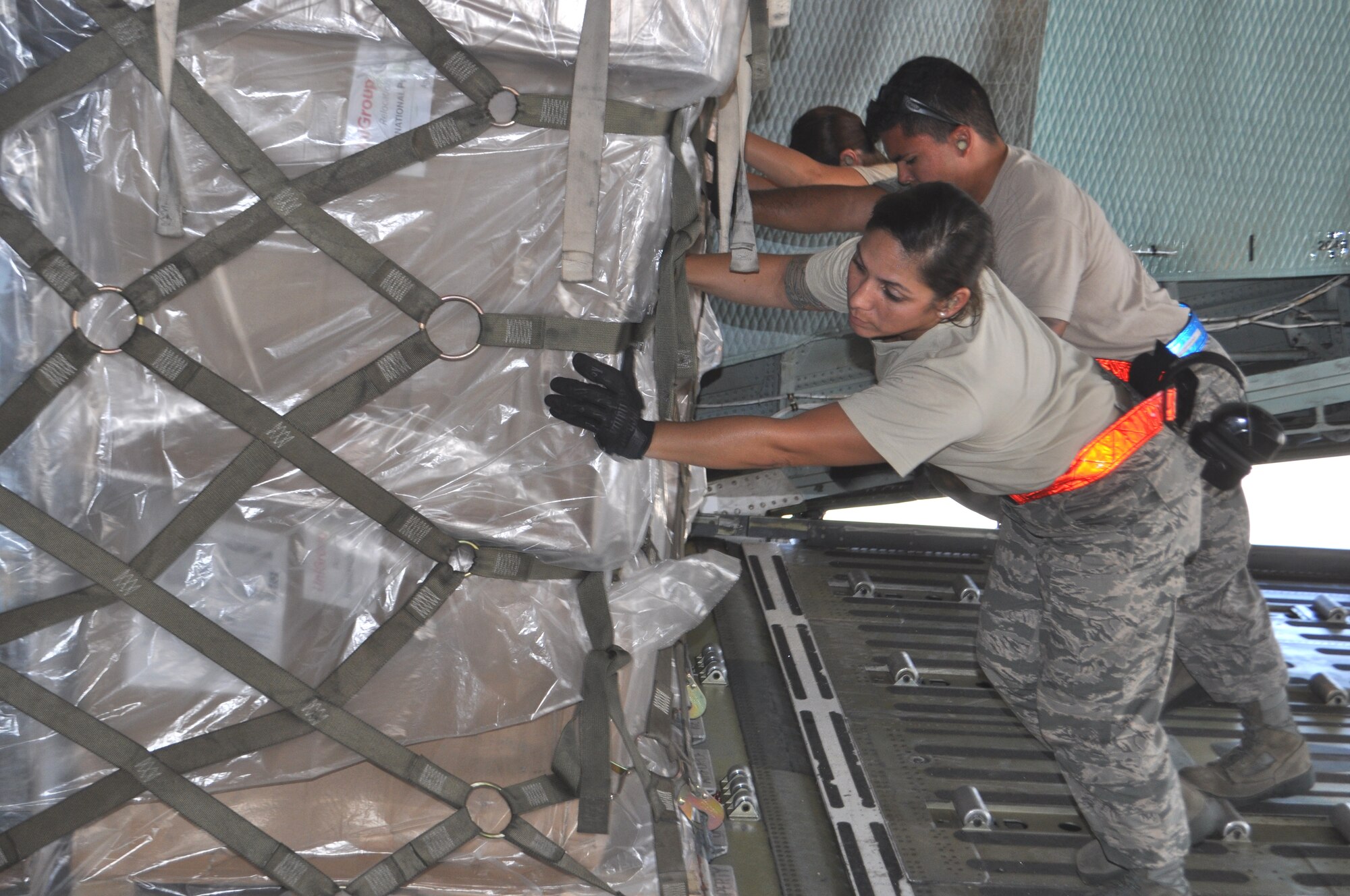 TRAVIS AIR FORCE BASE, Calif. -- From the left: Tech. Sgt. Kelly Sobieski, A1C Zephaniah Valdez, and A1C Jessica Cummings guide a pallet onto a Westover Air Reserve Base, Massachusetts, C-5 Galaxy. All aerial port specialists, they had the opportunity to fully load the aircraft with 36 pallets of equipment and supplies. Working alongside the 60th APS, they completed the load side-by-side with another C-5 from the 433rd Airlift Wing, Joint Base San Antonio, Texas, being loaded at the same time. Sobieski is a reservist with the 26th APS from the Texas base, Valdez is with the 60th APS, and Cummings is a reservist with the 82nd APS at Travis. (U.S. Air Force photo/Ellen Hatfield)