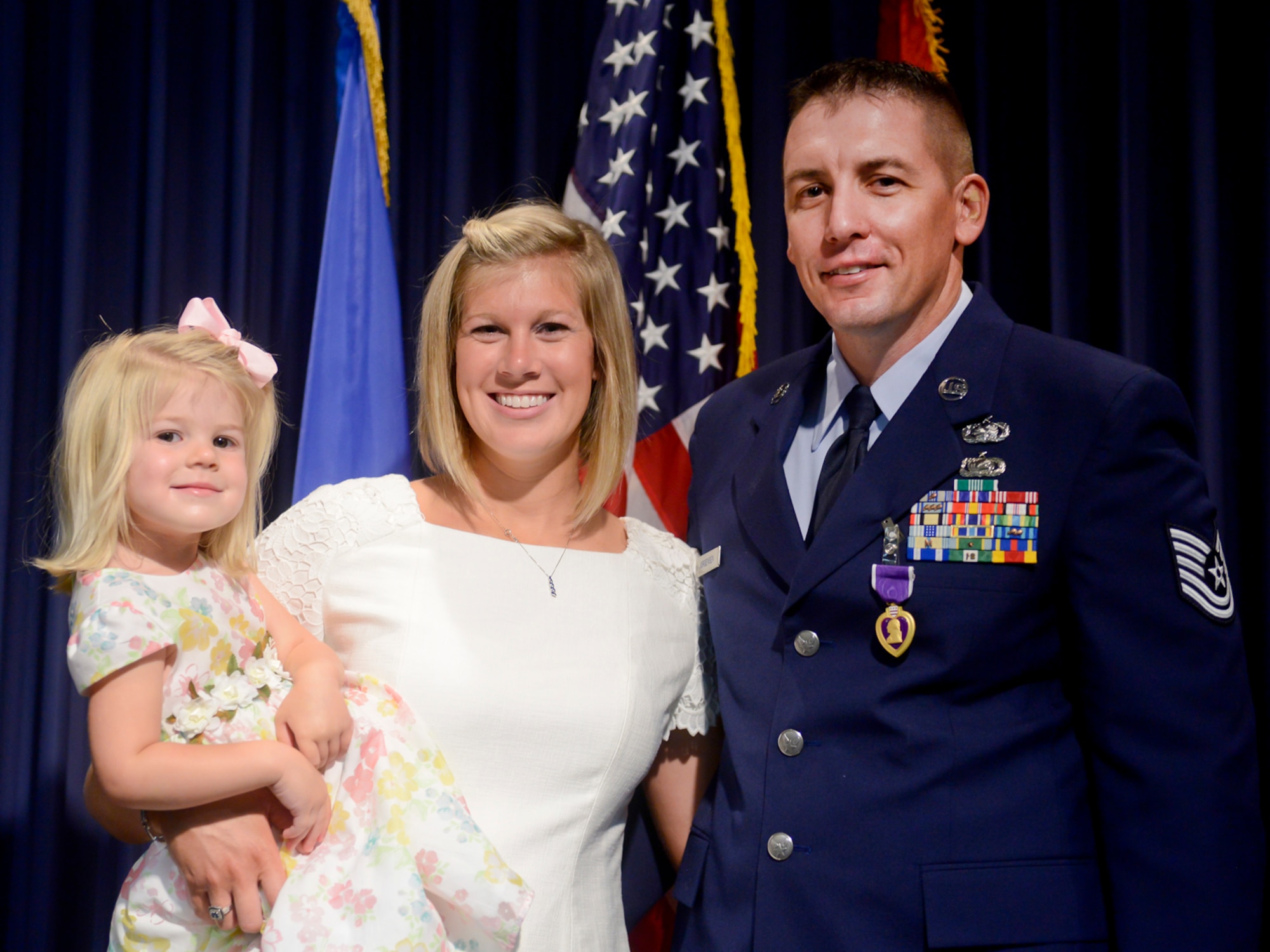 Oklahoma Air National Guard Tech. Sgt. Kody Jorgensen, assigned to the 138th Logistics Readiness Squadron, stands with his wife Quatie and daughter Kuwayah after receiving a Purple Heart Sept. 6, 2014, at the Tulsa Air National Guard base, Tulsa Okla. Jorgensen was wounded August 27, 2012, while serving in Afghanistan with the Georgia National Guard's 265th Regional Support Group, Agri-business Development Team II.  (U.S. National Guard photo by Master Sgt.  Mark A. Moore/Released)