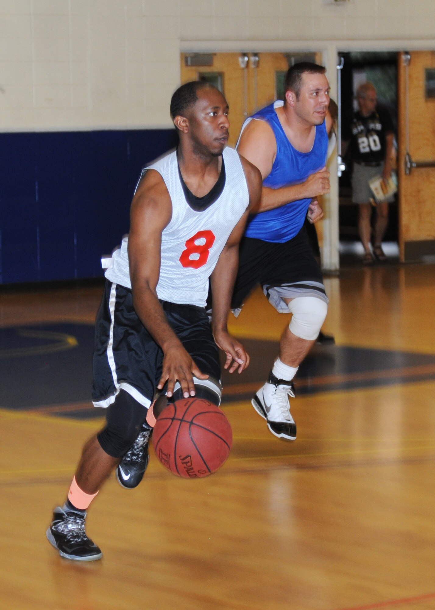 Marcus Toney, Gulfport Army Recruiting Station team, dribbles the ball down the court while Thomas Hefty, 81st Aerospace Medicine Squadron team, follows close behind during an intramural basketball game Sept. 9, 2014, at the Blake Fitness Center, Keesler Air Force Base, Miss.  Following double overtime, the Gulfport Army Recruiting Station team defeated the 81st AMDS team, 74-68. (U.S. Air Force photo by Kemberly Groue)