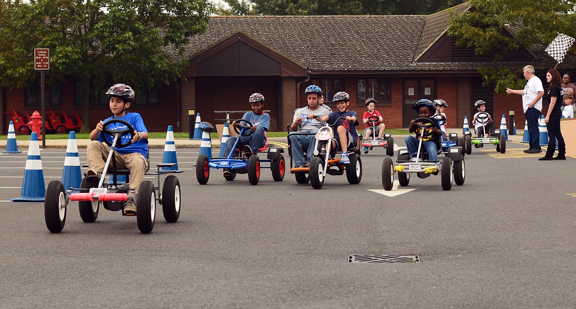 Team Mildenhall and Liberty Wing children race one another on pedal go-karts during the 100th Force Support Squadron Youth Center Day for Kids Sept. 6, 2014, at RAF Mildenhall, England. Day for Kids is an annual event filled with games, food and fun. (U.S. Air Force photo/Airman 1st Class Jonathan Light/Released)