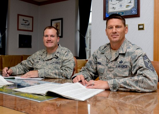 U.S. Air Force Col. Kenneth T. Bibb Jr., left, 100th Air Refueling Wing commander, and U.S. Air Force Chief Master Sgt. Tracy Jones, 100th ARW command chief, prepare to sign Combined Federal Campaign donation forms in Bibb’s office Sept. 10, 2014, on RAF Mildenhall, England. The CFC is a voluntary program which provides federal employees the opportunity to donate to charities through payroll deductions or a one-time payment. The campaign will run through Nov. 7, 2014. (U.S. Air Force photo/Senior Airman Victoria H. Taylor/Released)