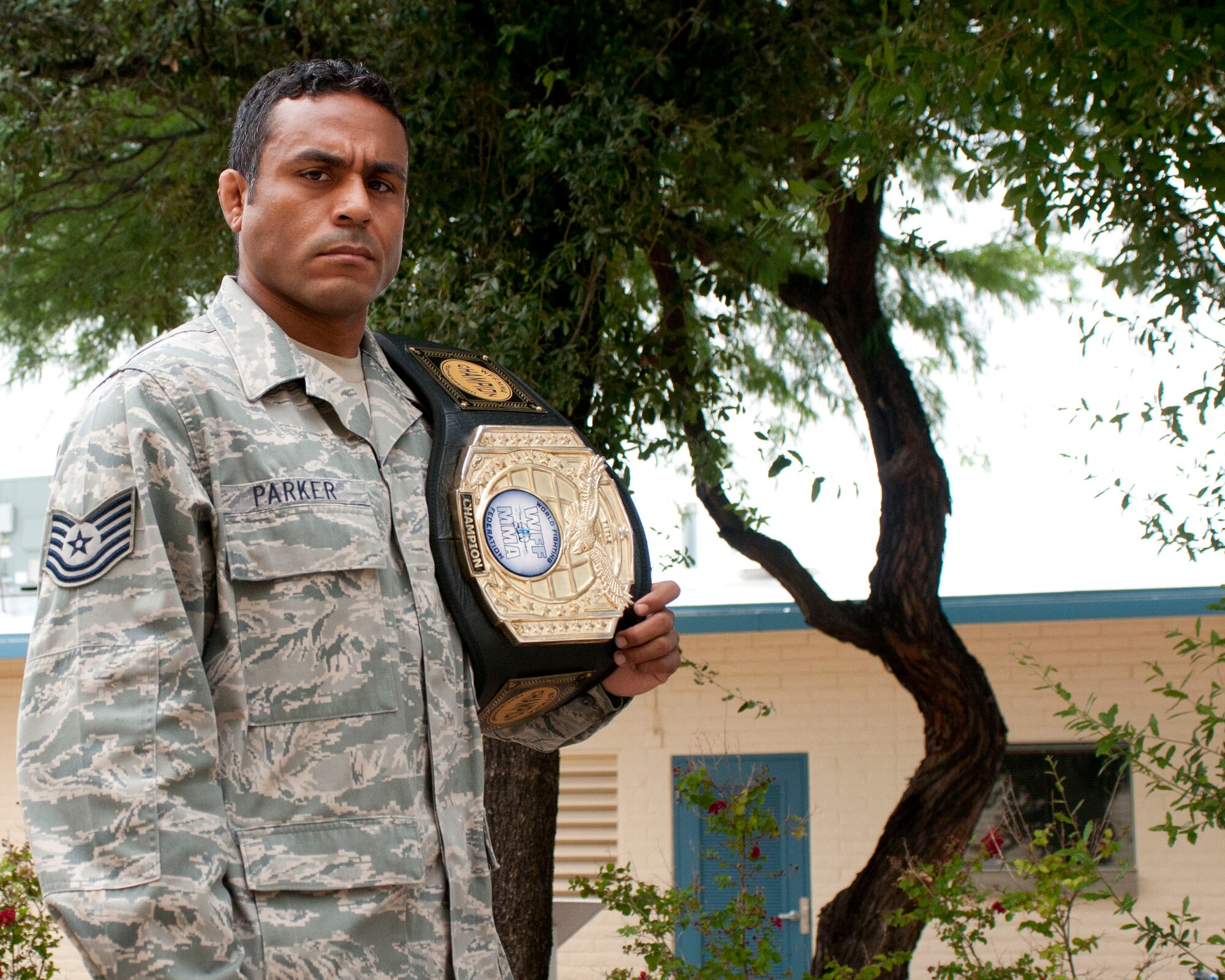 Tech. Sgt. Michael Parker fiercely displays a World Fighting Federation and Mixed Martial Arts belt at the 162nd Wing. The aircraft engine mechanic is slated to fight in the prominent Bellator MMA promotion fight at Grand Canyon University in Phoenix, Ariz. on Sept. 26, 2014. “Mixed martial arts is for everybody – just try it out and ask questions,” said Parker. (U.S. Air National Guard photo by Staff Sgt. Dina A. Farmer/Released)