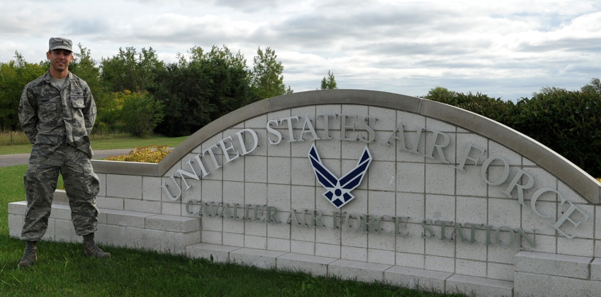 Second Lt. Brendan Morin, 10th Space Warning Squadron standards and evaluations chief, stands beside a sign at the front gate at Cavalier Air Force Station, N.D., Sept. 9, 2014. Morin was selected as the 10th SWS Warrior of the Week for the second week in September 2014. (U.S. Air Force photo/Airman 1st Class Bonnie Grantham)