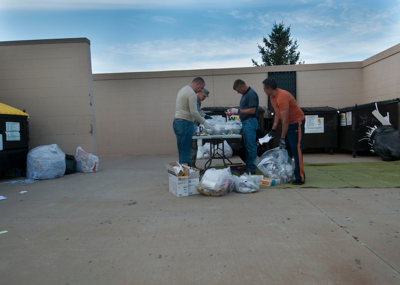 Col. Marc Caughey (left), 50th Space Wing vice commander, Lt. Col. Bart Hughes, 50th Space Wing chief Plans and Programs, and members of the 50 SW XP sift through trash looking for operational security violations Sept. 4,2014, at Schriever Air Force Base, Colo. The “dumpster dive” is an on-going base OPSEC effort to prevent critical/sensitive/PII information from being thrown away carelessly. (Air Force photo/Senior Airman Naomi Griego)
