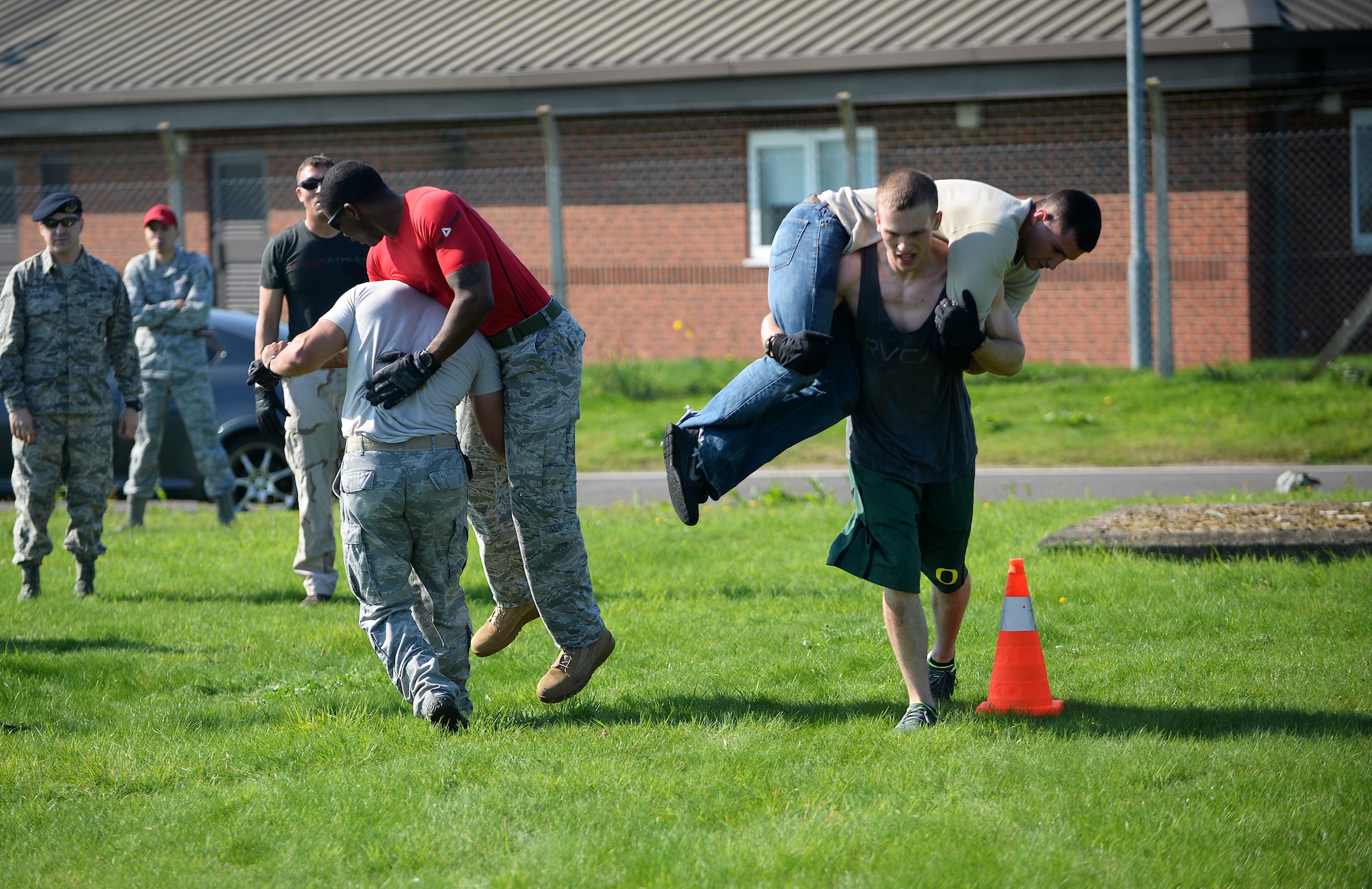 Members of the 48th Security Forces Squadron and 48th Civil Engineer Squadron carry each other during Warrior Challenge between Royal Air Forces Lakenheath and Mildenhall first responders as part of a week-long Battle of the Badges competition on RAF Feltwell, England, Sept. 8, 2014. The event promoted team building and camaraderie between security forces and firefighters in the tri-base area. (U.S. Air Force photo by Staff Sgt. Emerson Nuñez/Released)