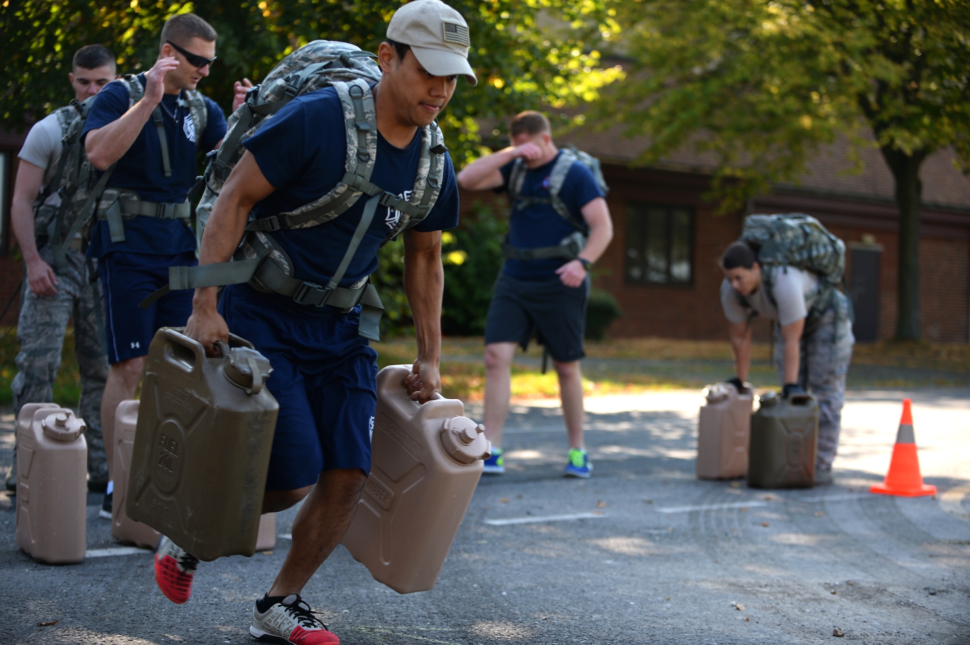 Staff Sgt. Minh Thlang, 100th Civil Engineer Squadron firefighter, races with two 20-Liter fuel tanks during Warrior Challenge between Royal Air Forces Lakenheath and Mildenhall security forces and firefighters as part of a Battle of the Badges competition on RAF Feltwell, England, Sept. 8, 2014. Other events throughout the week included a golf tournament, retreat ceremony, best-of-three softball tournament and powder-puff football game. (U.S. Air Force photo by Staff Sgt. Emerson Nuñez/Released)