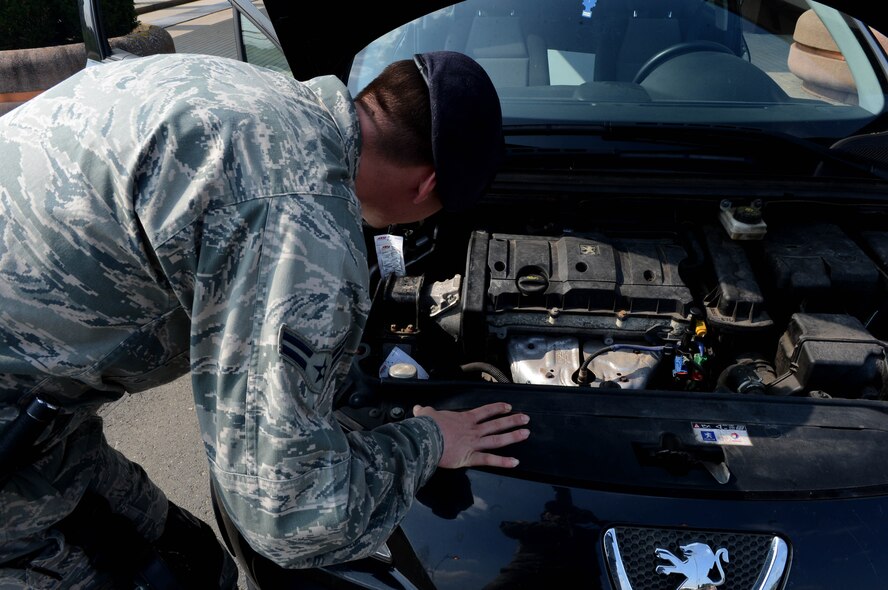 U.S. Air Force Airman 1st Class Justin Barber, 52nd Security Forces Squadron entry controller and native of Jacksonville, Fla., searches the engine-well of a vehicle before it is allowed entrance to Spangdahlem Air Base, Germany, Sept., 9, 2014. Every Airman is responsible for base defense and is encouraged to contact their anti-terrorism staff or Eagle Eyes program to report suspicious activity. (U.S. Air Force photo by Airman 1st Class Kyle Gese/Released) 