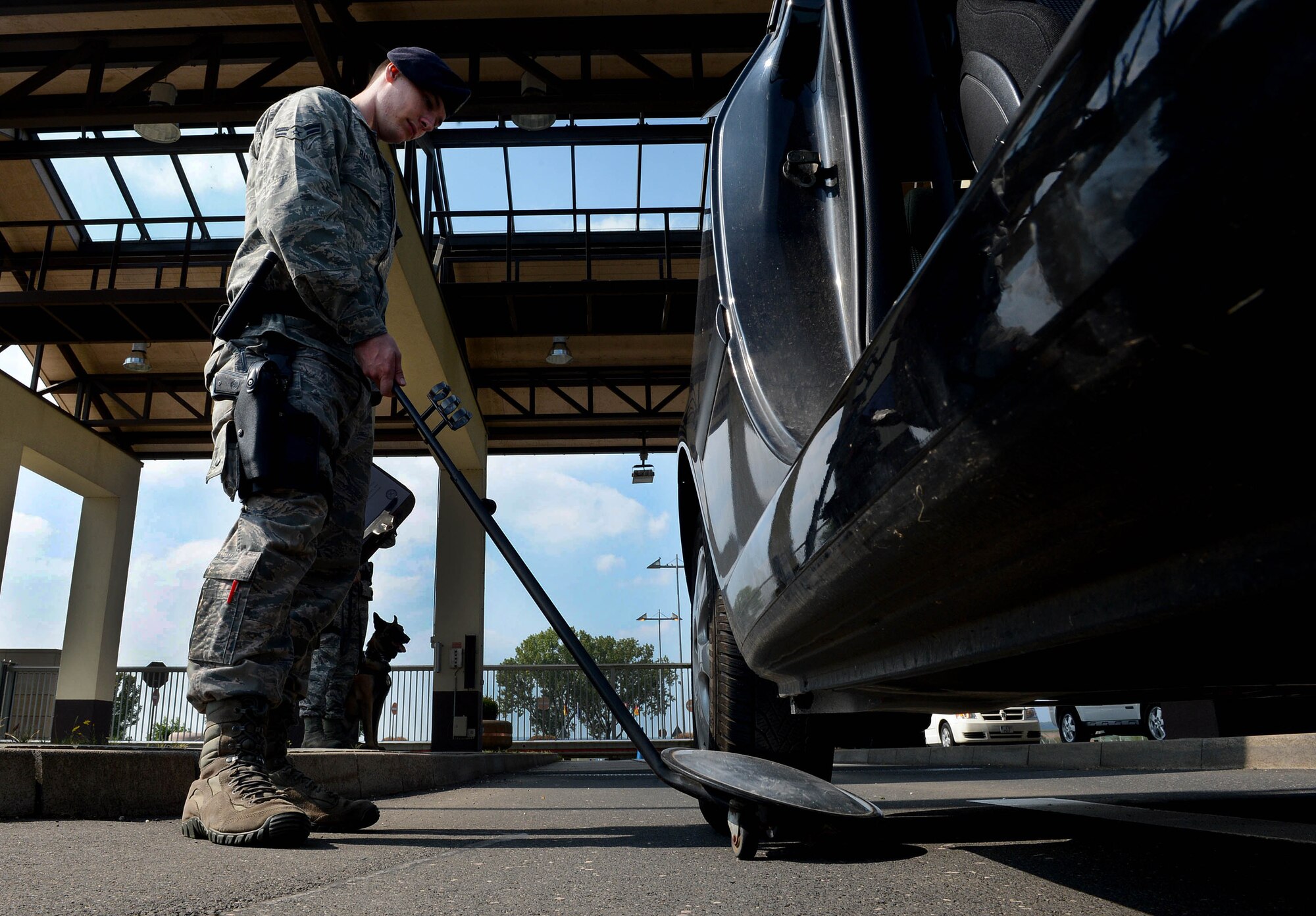 U.S. Air Force Airman 1st Class Justin Barber, 52nd Security Forces Squadron entry controller and native of Jacksonville, Fla., uses a mirror to search the undercarriage of a vehicle before it is allowed entrance to Spangdahlem Air Base, Germany, Sept., 9, 2014. Security forces entry controllers perform random vehicle inspections to ensure the base remains safe. They also encourage Airmen and families to use a program called Eagle Eyes that allows anyone to report suspicious activity. (U.S. Air Force photo by Airman 1st Class Kyle Gese/Released)