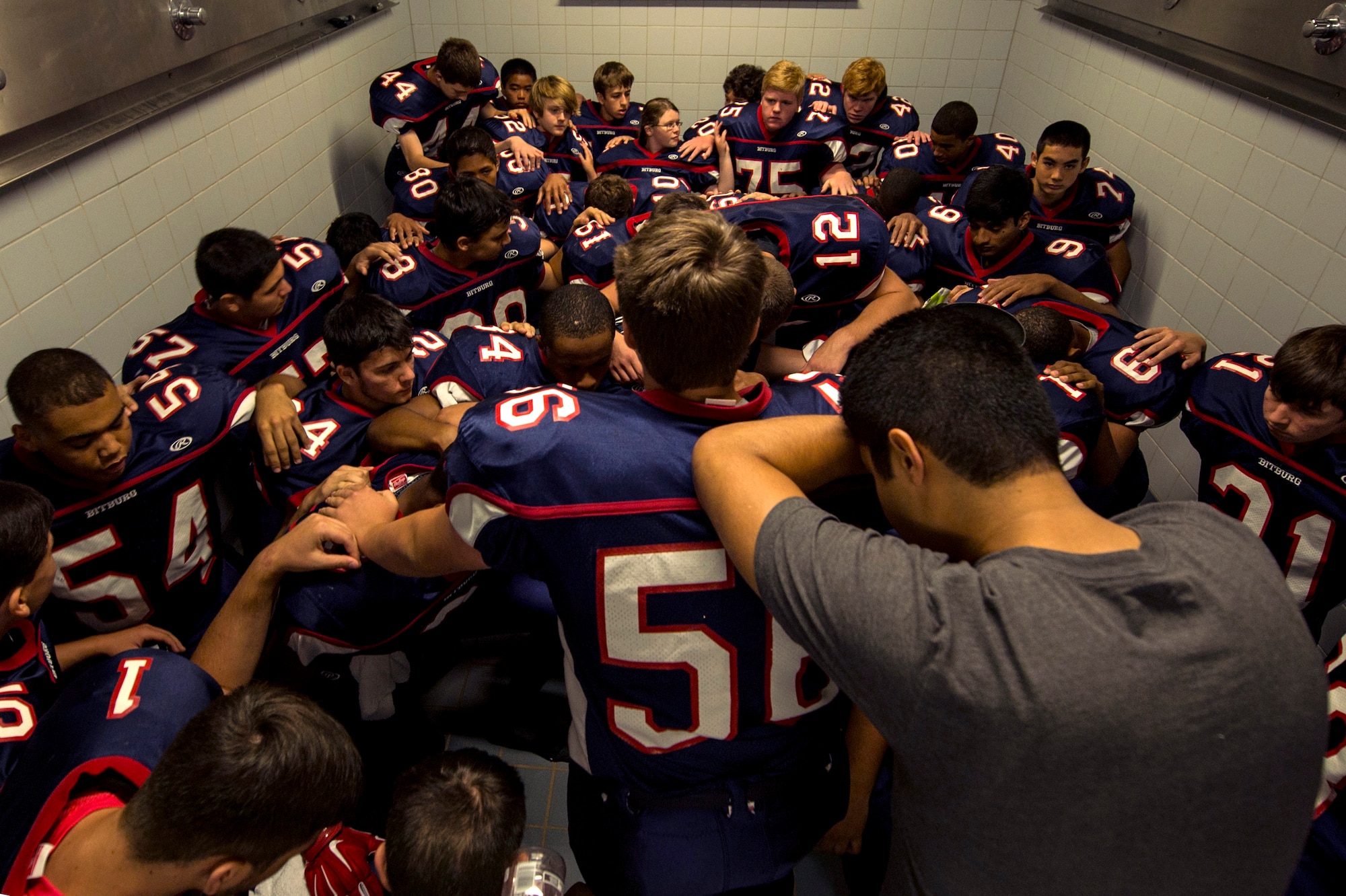 Bitburg Barons football players pray prior to the start of their season opener game against the Baumholder Buccaneers Sept. 6, 2014, at Bitburg Annex, Germany. The team comprises more than 30 players. (U.S. Air Force photo by Senior Airman Rusty Frank/Released)