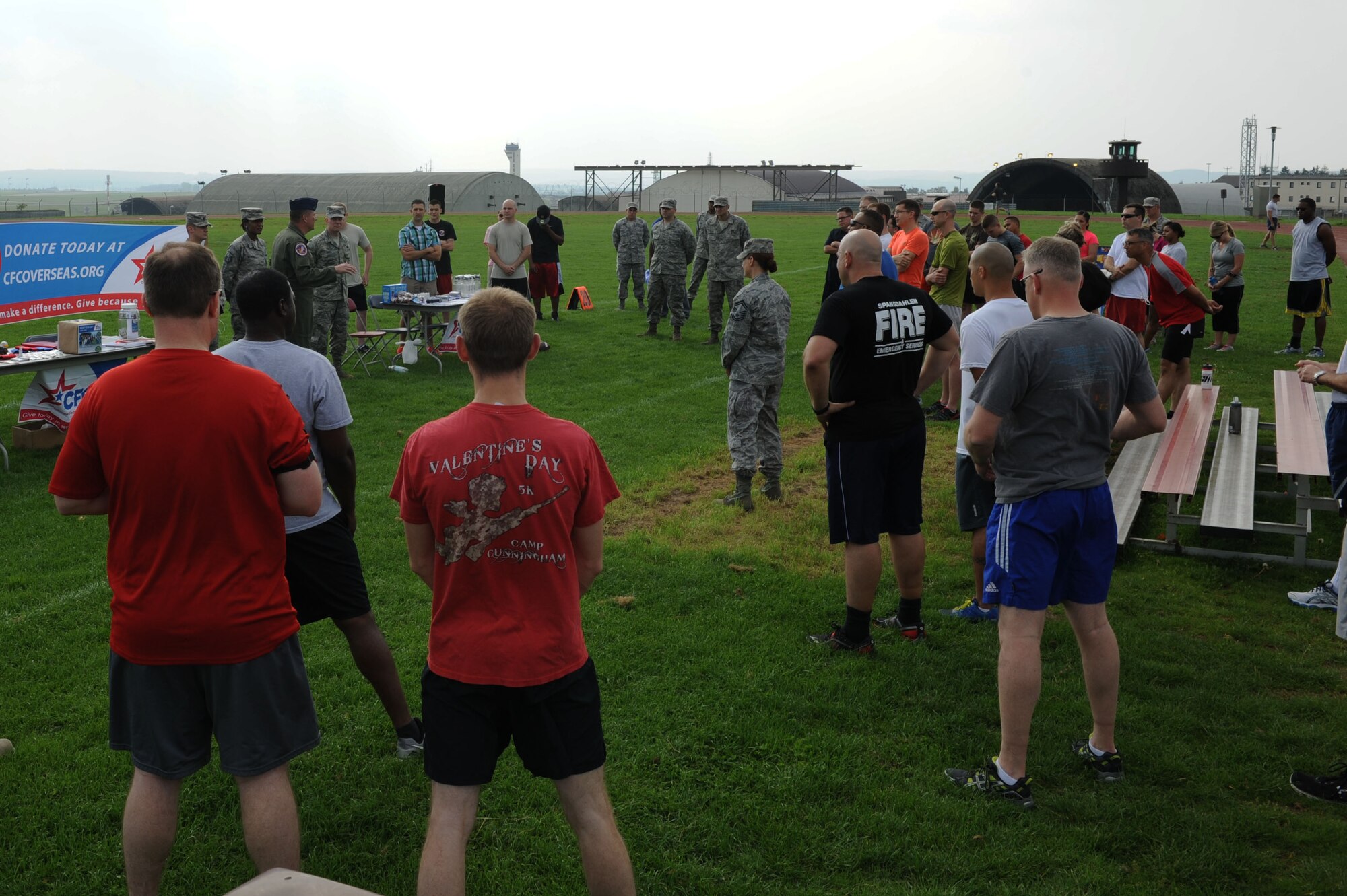 Airmen and families listen as U.S. Air Force Col. Pete Bilodeau, 52nd Fighter Wing commander, speaks during the 2014 Combined Federal Campaign-Overseas kickoff Sept. 8, 2014, at Spangdahlem Air Base, Germany. More than 50 community members participated in the event that featured a 5K run and a field-goal competition. (U.S. Air Force Photo by Airman 1st Class Dylan Nuckolls/Released)