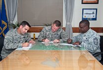Colonels Ken “Wolf” Ekman, 8th Fighter Wing commander (center), Jeffery “Wolf II” Valenzia, 8th FW vice commander (left), and Chief Master Sgt. Lee “Wolf Chief” Barr, 8th FW command chief (right), sign their Combined Federal Campaign-Overseas pledges at Kunsan Air Base, Republic of Korea, Sept. 8, 2014. The CFC-O is the only approved charity drive for federal employees and offers thousands of charities from which to choose. (U.S. Air Force photo by Senior Airman Divine Cox)
