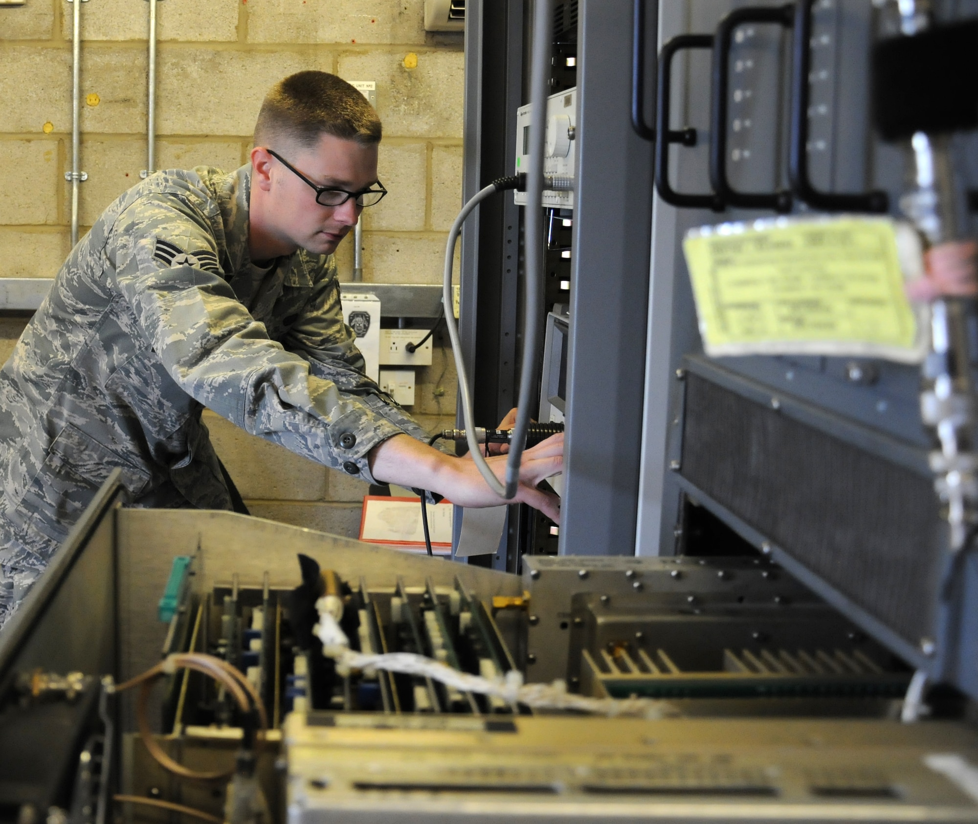 U.S. Air Force Senior Airman Trevin Brecheisen, 100th Communications Squadron Airfield Systems technician from Sacramento, Calif., adjusts different parameters to ensure they are within required specifications Sept. 3, 2014, on RAF Mildenhall, England. The Airman ensures parameters are at a correct level so the equipment can operate effectively. (U.S. Air Force photo/Gina Randall/Released)