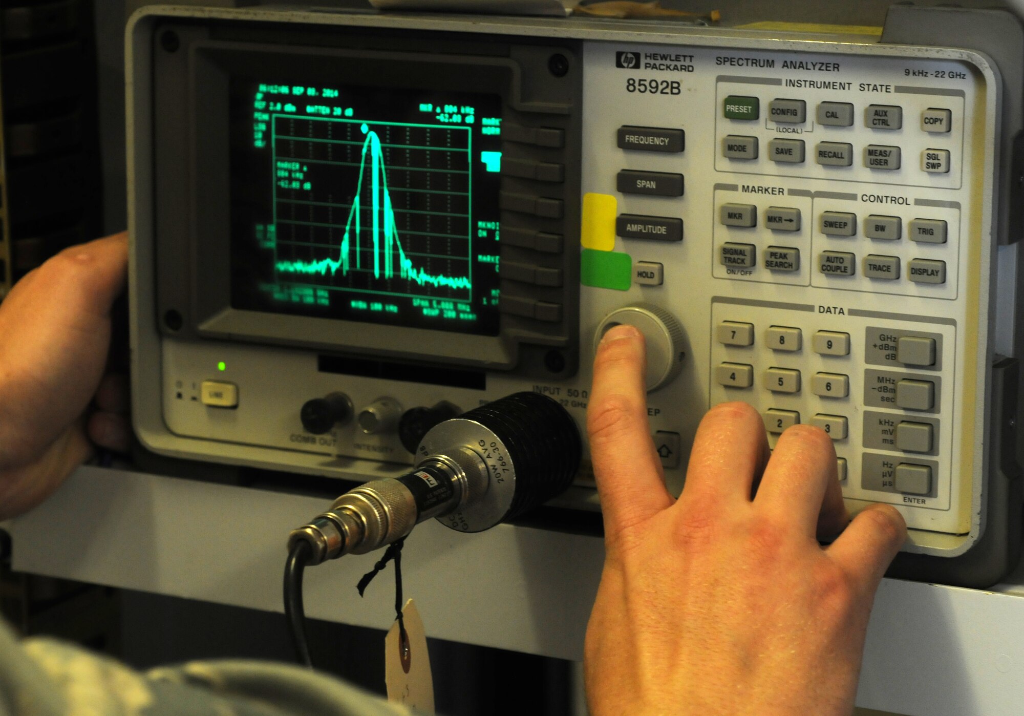 U.S. Air Force Senior Airman Trevin Brecheisen, 100th Communications Squadron Airfield Systems technician from Sacramento, Calif., confirms a spectrum analyzer is operating correctly Sept. 3, 2014, on RAF Mildenhall, England. The spectrum analyzer measures different outputs of the Tactical Air Navigation so technicians can see the signal pilots use to determine their location in flight. (U.S. Air Force photo/Gina Randall/Released)