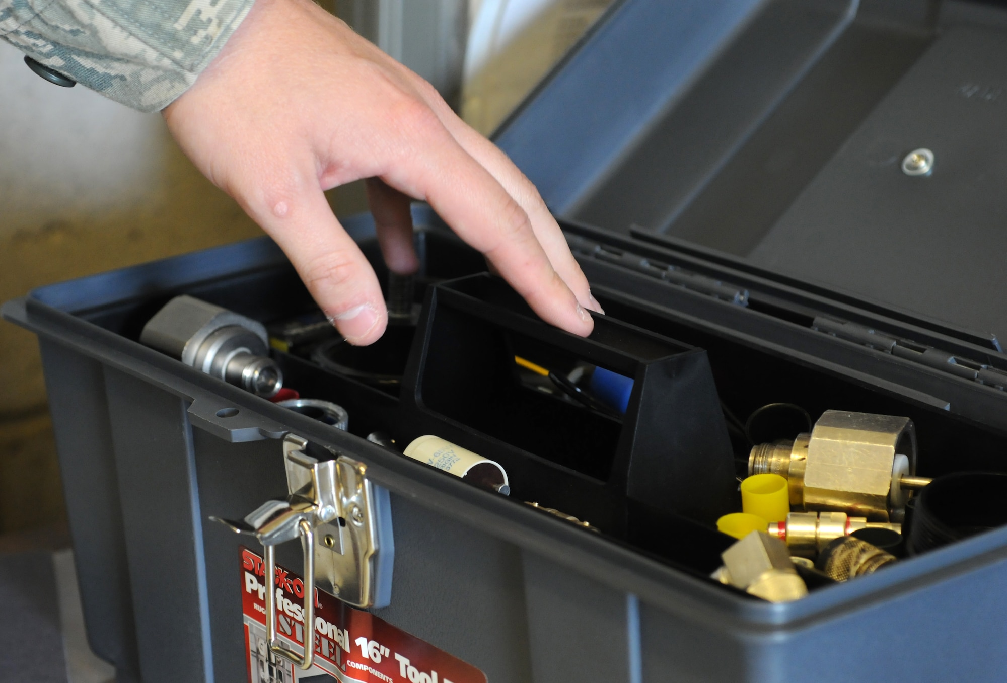 U.S. Air Force Senior Airman Trevin Brecheisen, 100th Communications Squadron Airfield Systems technician from Sacramento, Calif., selects tools to open a Tactical Air Navigation transponder Sept. 3, 2014, on RAF Mildenhall, England. The TACAN gives aircraft pilots distance and direction information to ensure they can navigate to the airfield safely. (U.S. Air Force photo/Gina Randall/Released)