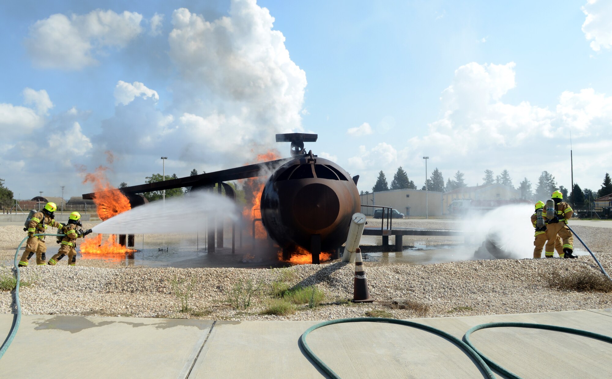 Firefighters from the 39th Civil Engineer Squadron Incirlik Fire Emergency Services, distinguish an aircraft live fire during annual training, Sept. 9, 2014, at Incirlik Air Base, Turkey. Aircraft fires are one of many services the firefighters are qualified to respond to in emergencies. (U.S. Air Force photo by Staff Sgt. Caleb Pierce/Released)