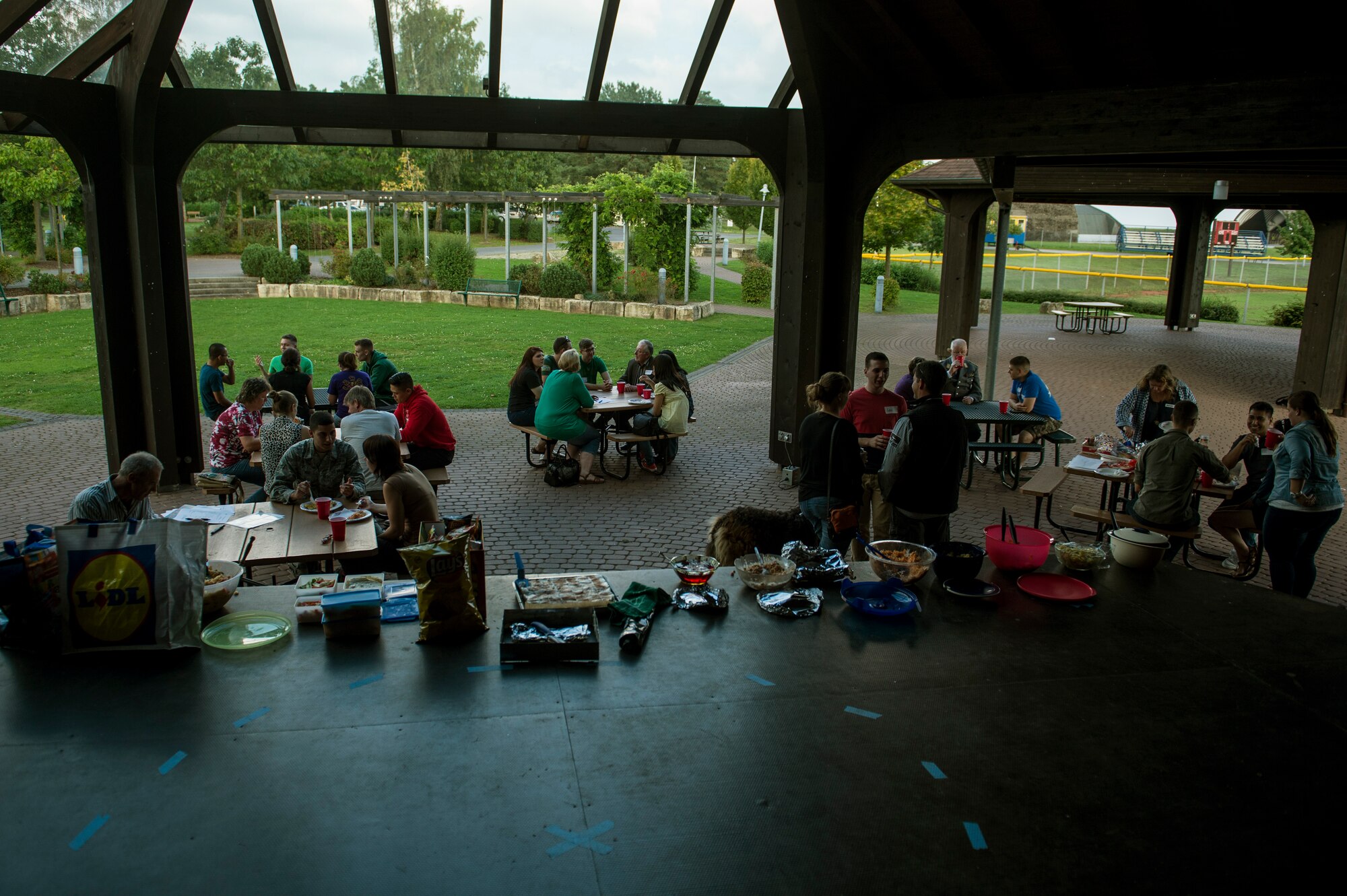 U.S. Airmen and German families socialize during the Adopt an Airman Program barbecue Sept. 5, 2014, at Spangdahlem Air Base, Germany. The program allows dorm Airmen to be adopted by a German family to share cultures and to provide a home away from home. (U.S. Air Force photo by Senior Airman Rusty Frank/Released)