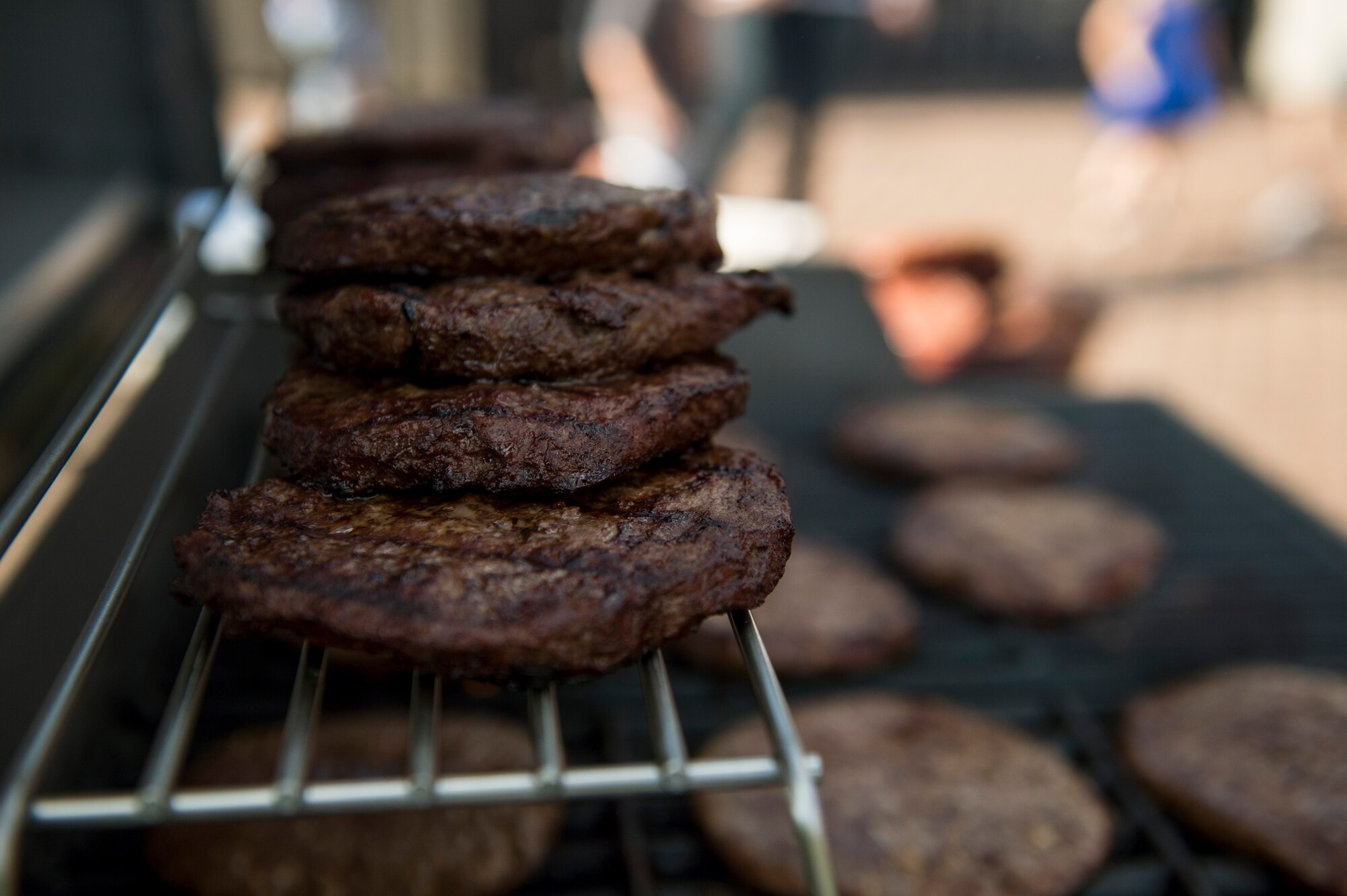 Hamburgers sit on a grill during the Adopt an Airman Program barbecue Sept. 5, 2014, at Spangdahlem Air Base, Germany. More than 55 German families and 20 Airmen signed up for the program, which allows a way for German and Airmen reach out to each other and share cultures. (U.S. Air Force photo by Senior Airman Rusty Frank/Released)
