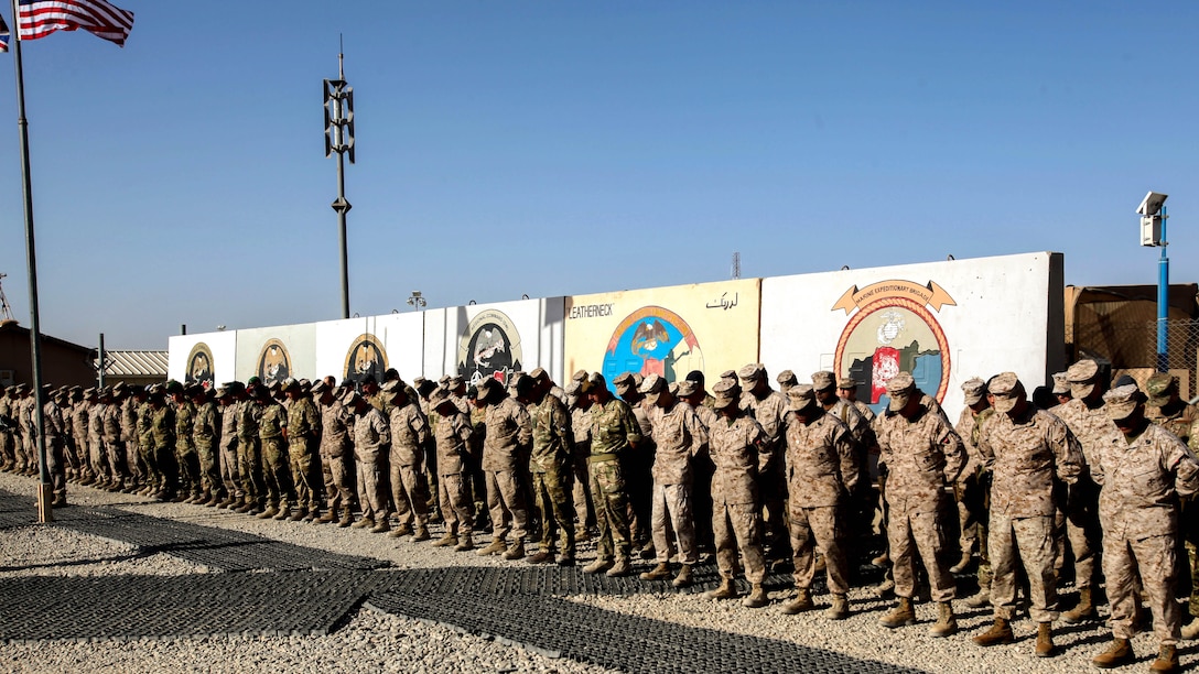 Marines, sailors and coalition partners with Regional Command (Southwest) bow their heads during a moment of silence at the 9/11 memorial ceremony aboard Camp Leatherneck, Afghanistan, Sept. 11, 2014. “That moment of silence gave us an opportunity to reflect and reminds us of why we are here today in Afghanistan in Helmand province,” said Brig. Gen. Daniel D. Yoo, commander, RC(SW) and Marine Expeditionary Brigade – Afghanistan.