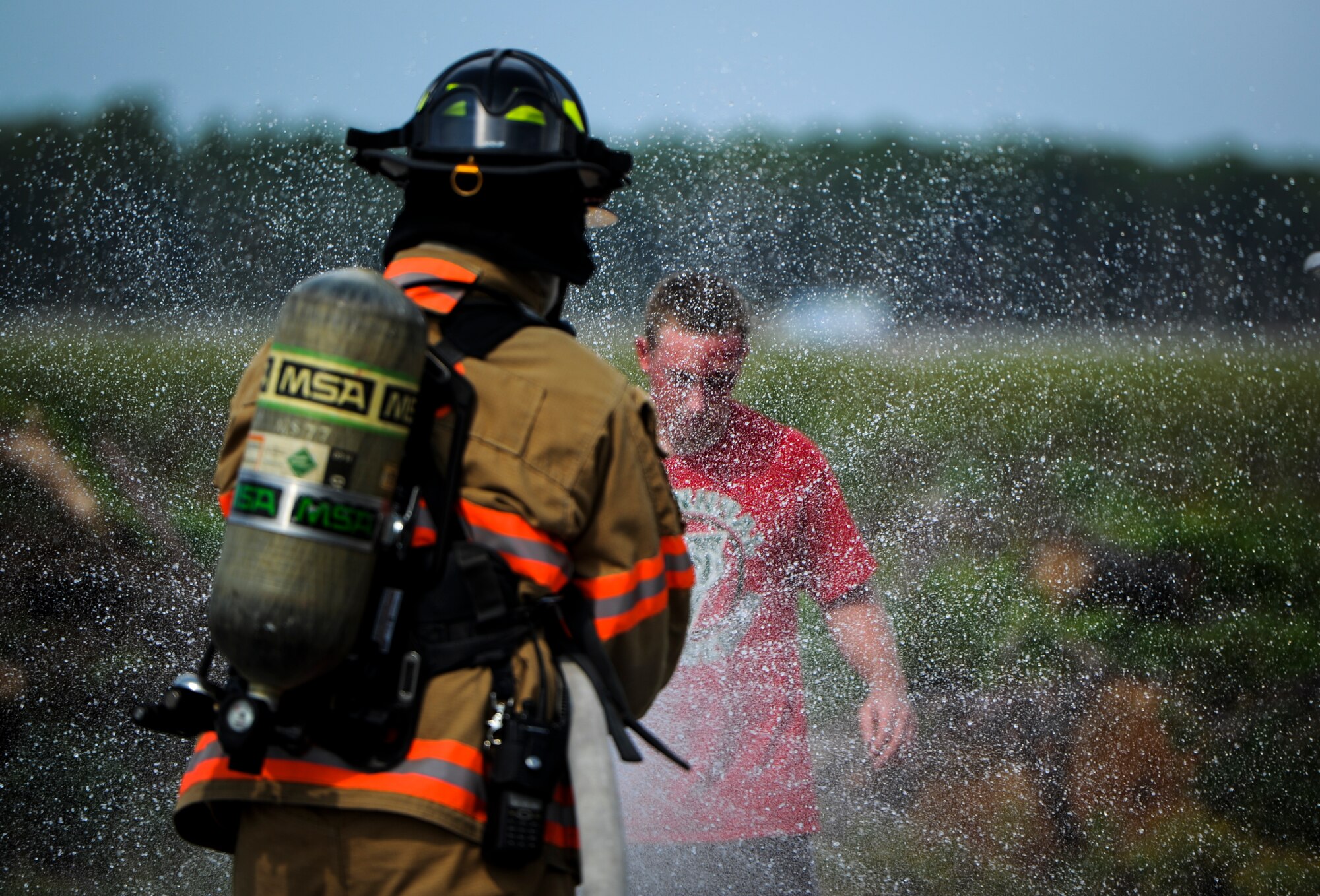 A 1st Special Operations Civil Engineer Squadron firefighter sprays down a role-playing victim during Exercise Commando Terror at Hurlburt Field, Fla., Sept. 8 2014. During the exercise, a simulated domestic bomb exploded leaving harmful chemicals in the area, which triggered the responders to rinse the victims before providing proper medical treatment. (U.S. Air Force photo/Senior Airman Christopher Callaway) 