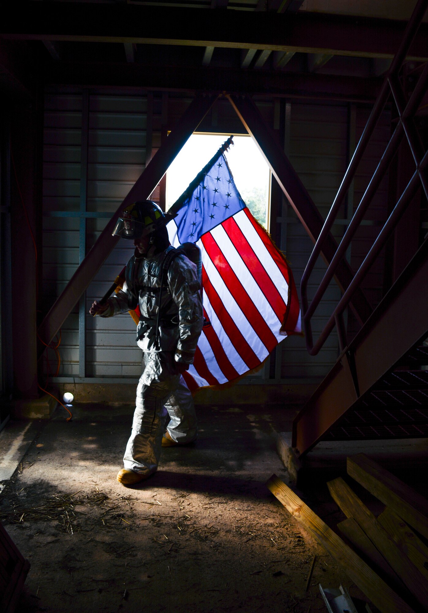 Staff Sgt. Chase Blair carries the U.S. flag during the 5th Annual Fire Climb Sept. 7, 2014, at the fire training tower at Tinker Air Force Base, Okla. Blair is a firefighter with the 507th Civil Engineer Squadron. Reservists from the CES and 507th ARW took turns carrying the flag up and down the equivalent of 110 stories to commemorate the 343 firefighters, emergency medical technicians and paramedics who lost their lives during the 9/11 attacks on the World Trade Centers. (U.S. Air Force photo/Senior Airman Mark Hybers) 