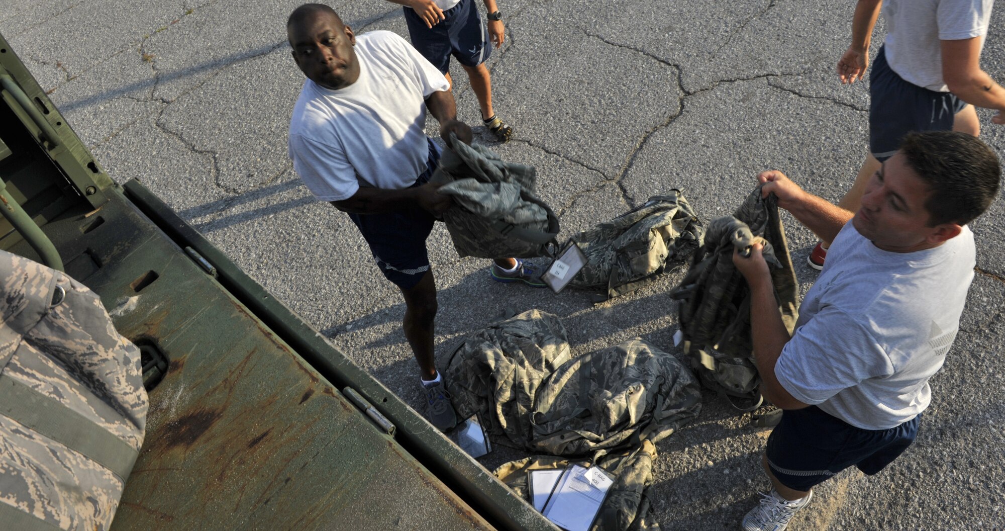 Master Sgt. Brian Butler and Staff Sgt. Lloyd Willits throw bags of sand on the back of a truck as part of the 2014 RED HORSE Rumble Obstacle course, Sept. 6, 2014 at Hurlburt Field, Fla. The course is part of an annual morale-boosting event hosted by the 556th RHS. (U.S. Air Force photo/Senior Airman Kentavist P. Brackin)