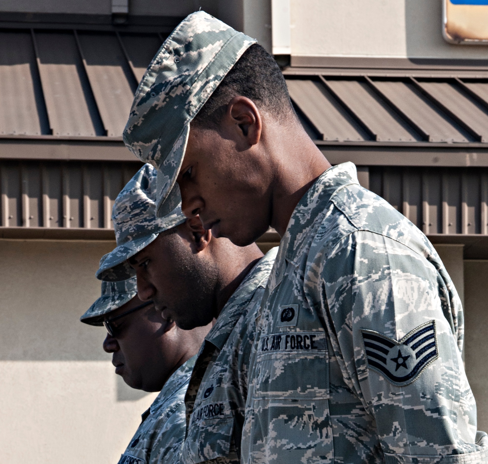 Chief Master Sgt. Lee “Wolf Chief” Barr, 8th Fighter Wing command chief, (left to right), Tech. Sgt. Mykal Donathan, 8th Aircraft Maintenance Squadron noncommissioned officer in charge, cannibalization dock, and Staff Sgt. Diron Smith, 8th Comptroller Squadron deputy dispersing officer, bow their heads during a moment of silence honoring the 13th anniversary of Sept. 11 at Kunsan Air Base, Republic of Korea. Donathan and Smith volunteered their personal accounts of 9/11 and how it impacted their lives and their decision to enlist in the U.S. Air Force. (U.S. Air Force photo by Senior Airman Katrina Heikkinen)