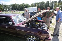 Marines with 2nd Marine Logistics Group, II Marine Expeditionary Force look at a car on display during the barracks bash at Goettge Memorial Field aboard Marine Corps Base Camp Lejeune, N.C., Aug. 27, 2014. The overall goal of the barracks bash was to maintain unit cohesion and build camaraderie amongst Marines by competing in several sport events. (Marine Corps photo by Lance Cpl. Tyler Andersen)