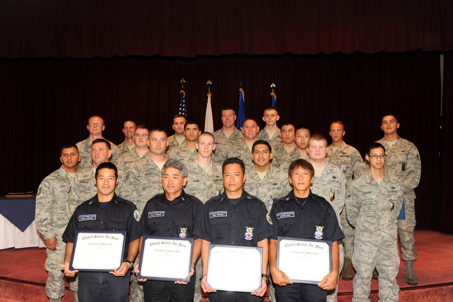 A group of Kadena first responders pose for a group photo after receiving Air Force Commendation medals, Air Force Achievement medals or outstanding achievement awards from U.S. Air Force Brig. Gen. James Hecker, 18th Wing commander, on Sept. 12, 2014. The group was responsible for rescuing two trapped airmen from a flooding guard shack during typhoon Neoguri on July 9, 2014. (U.S. Air Force photo by Airman 1st Class Stephen G. Eigel/Released)