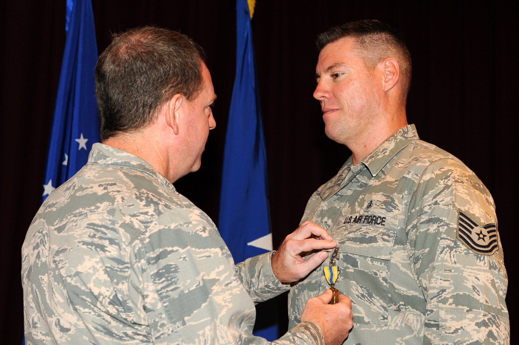 U.S. Air Force Tech. Sgt. Shawn Gilman, 18th Medical Operations Squadron aeorspace medical service craftsman, receives the Air Force Commendation medal from Brig. Gen. James Hecker, 18th Wing commander, on Kadena Air Base, Japan, Sept. 12, 2014. Gilmans ability to think and act quickly proved instrumental to the rescue of two security forces members trapped inside a flooding guard shack July 9, 2014. (U.S. Air Force photo by Airman 1st Class Stephen G. Eigel/Released)