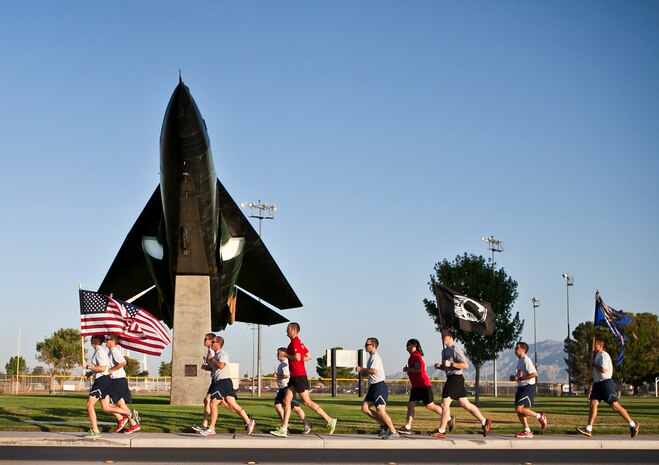 Members of Nellis Air Force Base jog past an F-111 Aardvark during the Old Glory Challenge at Freedom Park, Nellis AFB, Nev., Sept. 11, 2014. Nellis members and veterans throughout the Las Vegas community joined together to pay tribute to the victims of the 9/11 terrorist attacks and salute first-line responders for their heroic deeds. (U.S. Air Force photo by Lawrence Crespo)