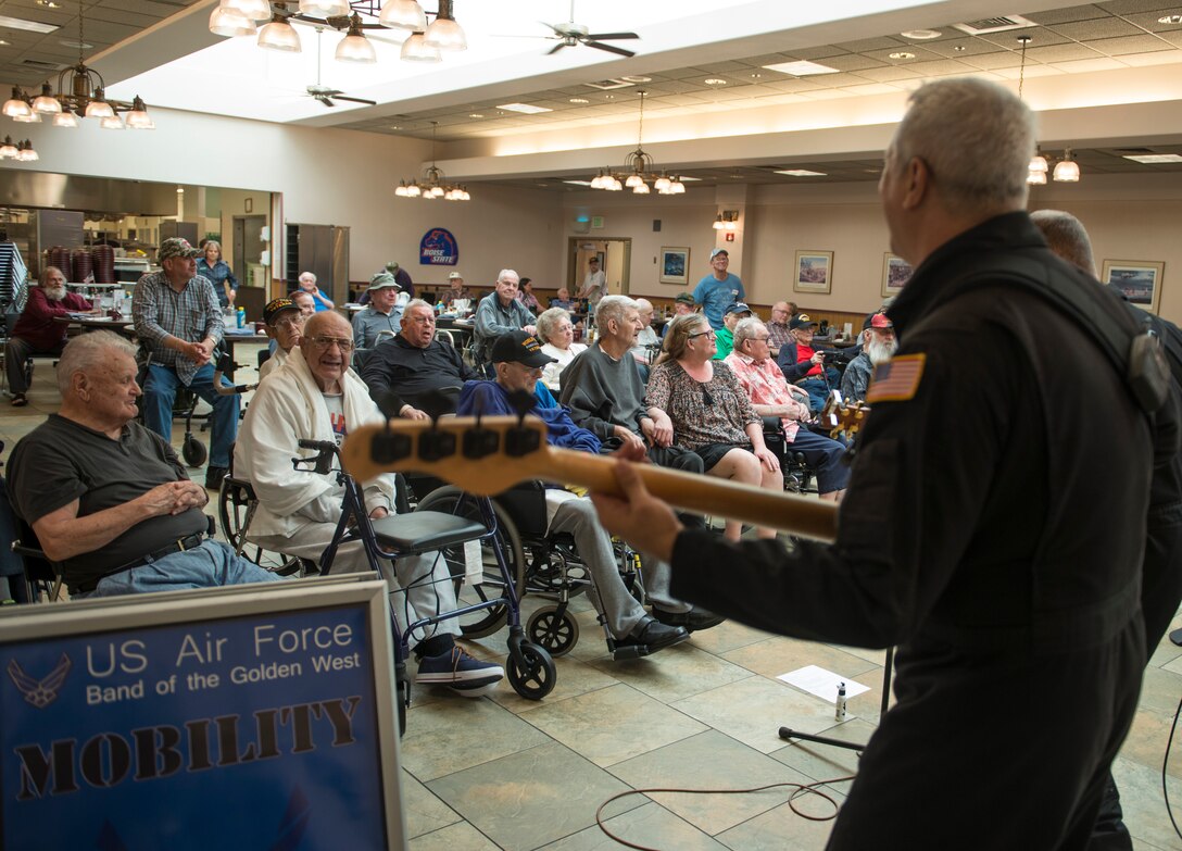 U.S. veterans watch as U.S. Air Force Master Sgt. Douglas Tejada plays bass guitar during a song at the Idaho State Veteran’s Home, Sept. 4, 2014. Mobility played numerous sets all around southern Idaho during their six-day tour. (U.S. Air Force photo by Airman 1st Class Brittany A. Chase/Released)