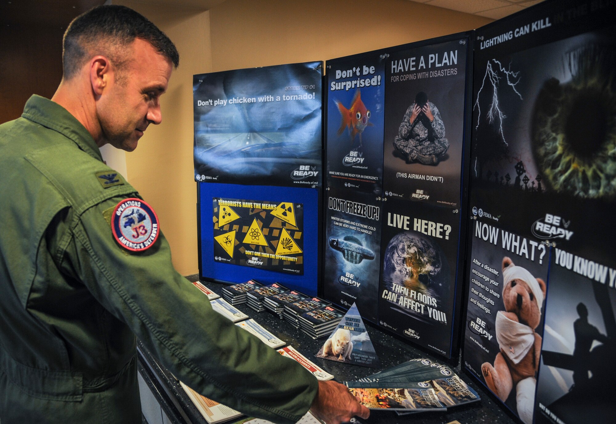 Col. David Kincaid, deputy command center director of North American Aerospace Defense Command and Northern Command, grabs a flyer from a National Preparedness Month display Sept. 4, 2014, at Little Rock Air Force Base, Ark. National Preparedness Month is observed during September and is sponsored by the Federal Emergency Management Agency. (U.S. Air Force photo by Airman 1st Class Harry Brexel)