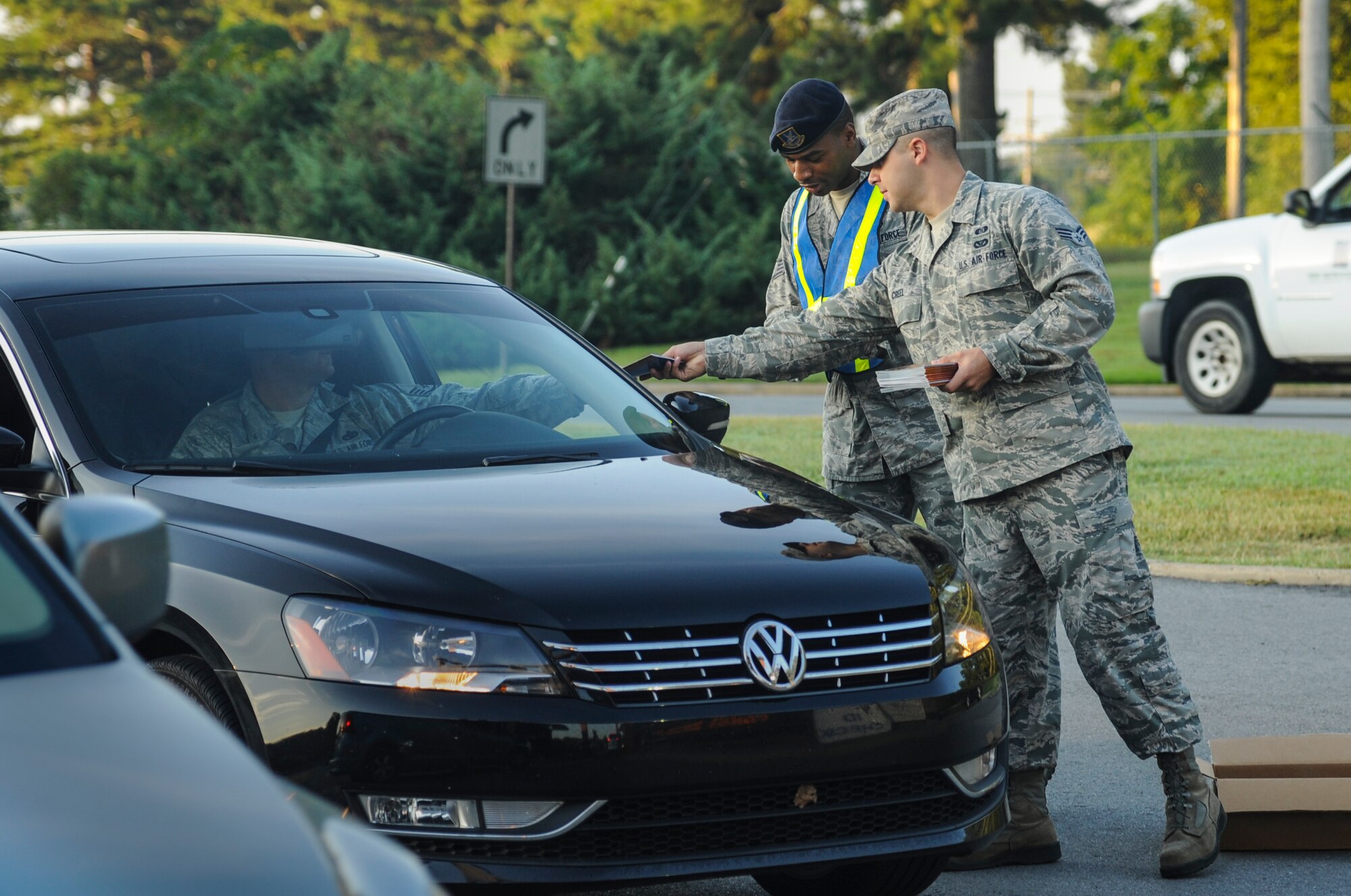 Senior Airman Justin Creel, a 19th Civil Engineering Squadron emergency management technician, passes out an Air Force Emergency Preparedness booklet to an Airman heading to work Sept. 4, 2014, at Little Rock Air Force Base, Ark. Every year during September, 19th CES Airmen teach Team Little Rock members how to prepare for emergencies like natural disasters. (U.S. Air Force photo by Airman 1st Class Harry Brexel)