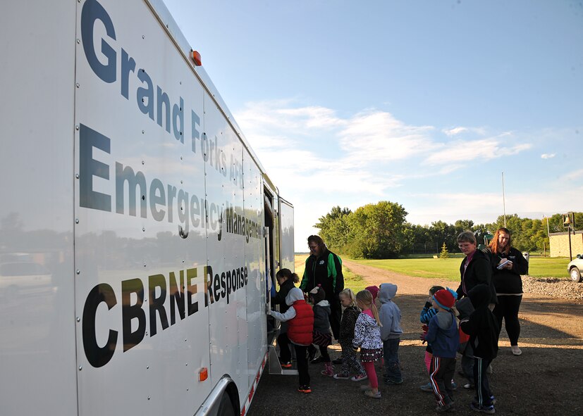 Pre-Kindergarten students from Emerado Elementary School line up to tour an Emergency Management Response trailer Sept. 11, 2014, in Emerado, N.D. The 319th Civil Engineer Squadron Readiness and Emergency Management Flight visited the school to talk about how to respond and prepare for any natural disasters or major accidents. (U.S. Air Force photo/Senior Airman Xavier Navarro)