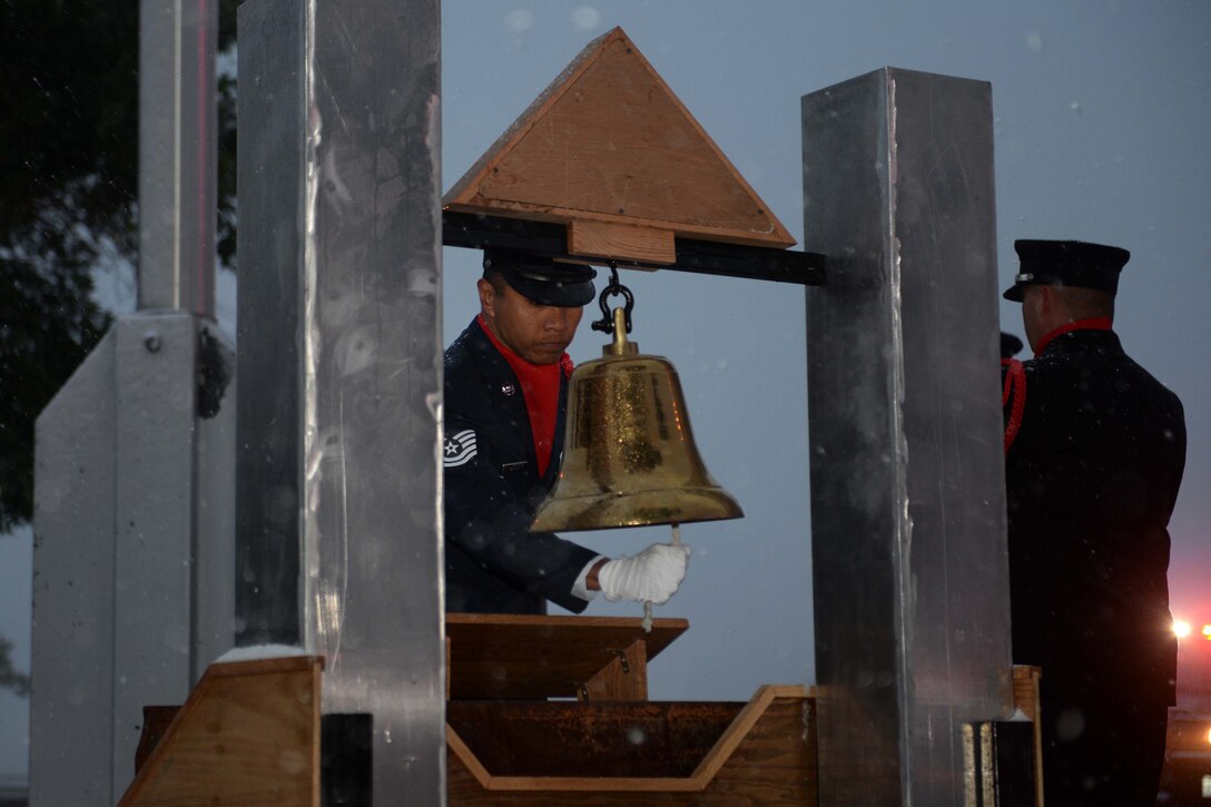 Tech. Sgt. Rodger Marquez, 28th Civil Engineer Squadron NCO in charge of fire dispatch, performs a signal 5-5-5 ceremony during a special 9/11 reveille ceremony at the base flagpole at Ellsworth Air Force Base, S.D., Sept. 11, 2014. Signal 5-5-5 consists of three sets of five bell rings and recognized in firehouses since 1870, signals a death-generally of a colleague-and signals firefighters to lower the U.S. flag to half staff. (U.S. Air Force photo by Airman 1st Class Rebecca Imwalle/ Released)