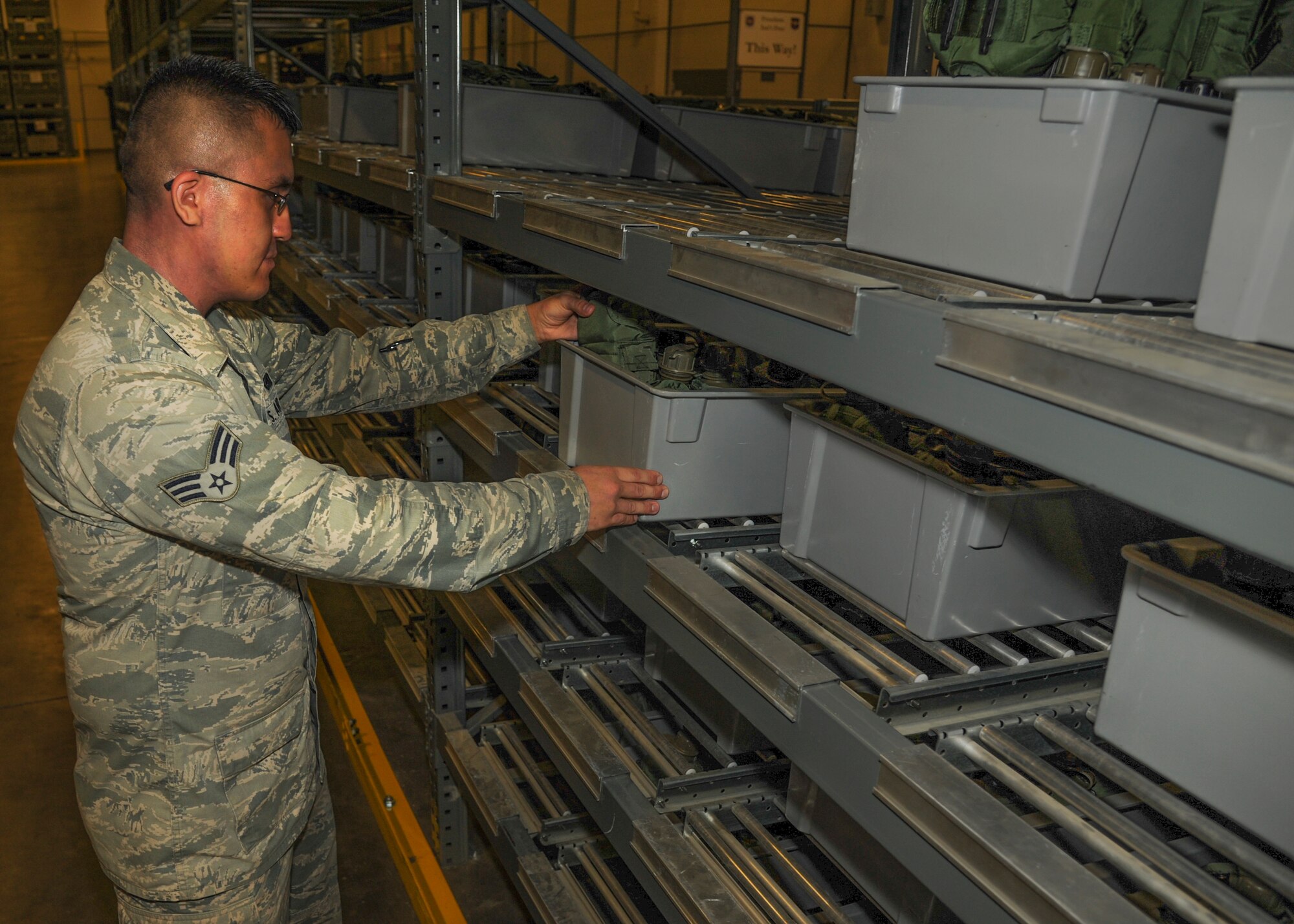 Senior Airman Michael Santos, a 19th Logistics Readiness Squadron operations journeyman, places a box of deployment gear on a shelf Sept. 8, 2014, at Little Rock Air Force Base, Ark. Santos was the main driver of the Installation Deployment Readiness Cell for the wing's September aviation deployment. (U.S. Air Force photo by Airman 1st Class Harry Brexel)