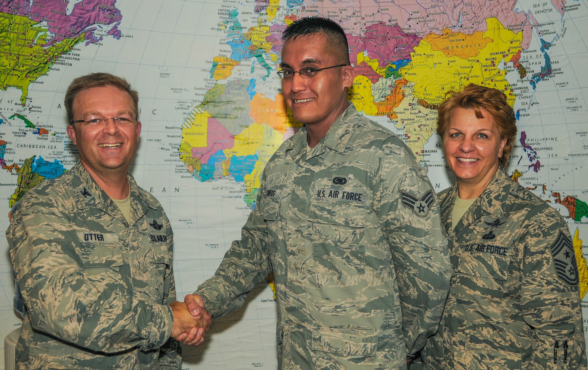 Col. William Otter, 19th Airlift Wing vice commander, and Chief Master Sgt. Rhonda Buening, 19th AW command chief, congratulate Senior Airman Michael Santos, a 19th Logistics Readiness Squadron operations journeyman, for his selection as Combat Airlifter of the Week Sept. 8, 2014, at Little Rock Air Force Base, Ark. Santos, a Wichita, Kansas, native, contributed to the 19th LRS by ensuring deployment readiness for the 19th Maintenance Group and 19th Operations Group and helped them earn an overall outstanding observation from wing safety. (U.S. Air Force photo by Airman 1st Class Harry Brexel) 