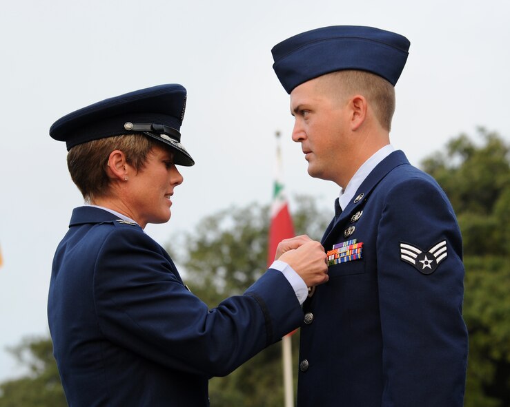 Col. Kristin Goodwin, 2nd Bomb Wing commander, presents Senior Airman TJ Brantley, 2nd Civil Engineer Squadron Explosive Ordinance Disposal technician, the Purple Heart during the 9/11 Remembrance Ceremony on Barksdale Air Force Base, La., Sept. 11, 2014. Brantley received wounds from an improvised explosive device that detonated within ten feet during a sustained firefight. In addition, Brantley received the Combat Action Medal for his participation in the firefight. (U.S. Air Force photo/Senior Airman Jannelle Dickey)