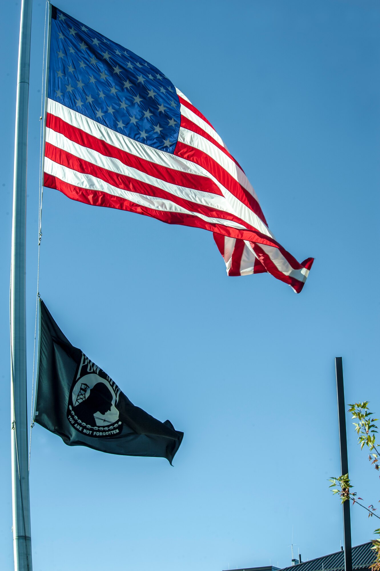 The American and prisoners of war/missing in action flags fly at half-staff at Fairchild Air Force Base, Washington, in honor of the 2,977 innocent lives lost on 9/11 in New York, the Pentagon and fields of Pennsylvania, Sept. 11, 2014. Although more than a decade has passed since the Sept. 11 attacks, time will never replace the lives lost on that day. The base will hold a remembrance ceremony today at 4 p.m. at the wing flag pole. (U.S. Air Force photo by Staff Sgt. Benjamin W. Stratton/Released)