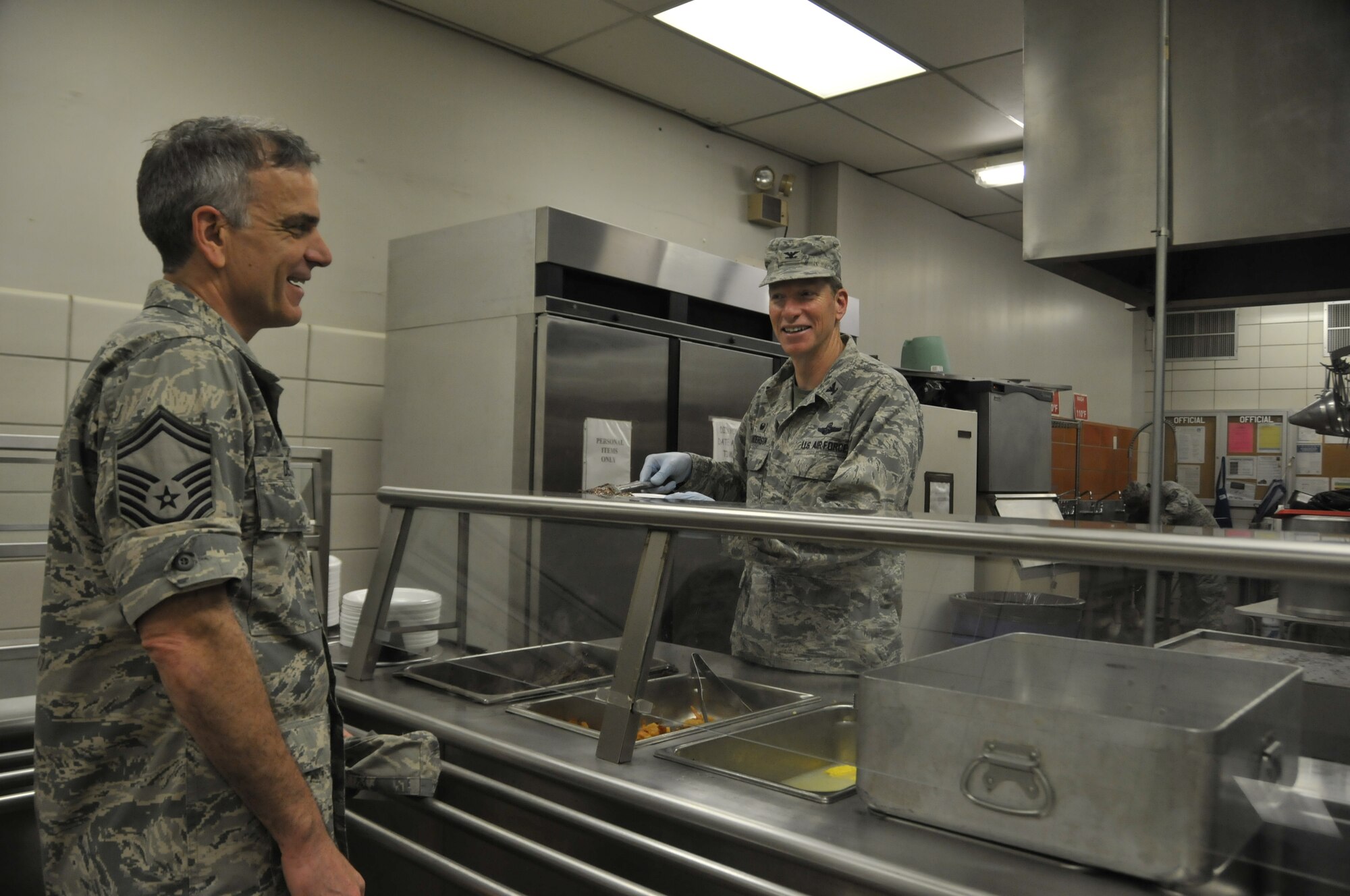 Col. Mark Anderson, 188th Wing commander, right, serves a "surf-n-turf" lunch meal to Senior Master Sgt. Nicholas DeGuire at Citizen Airman Dining Hall during a unit training assembly at Ebbing Air National Guard Base, Fort Smith, Arkansas on Sept. 7, 2014. (U.S. Air National Guard photo by Staff Sgt. John Suleski/released)