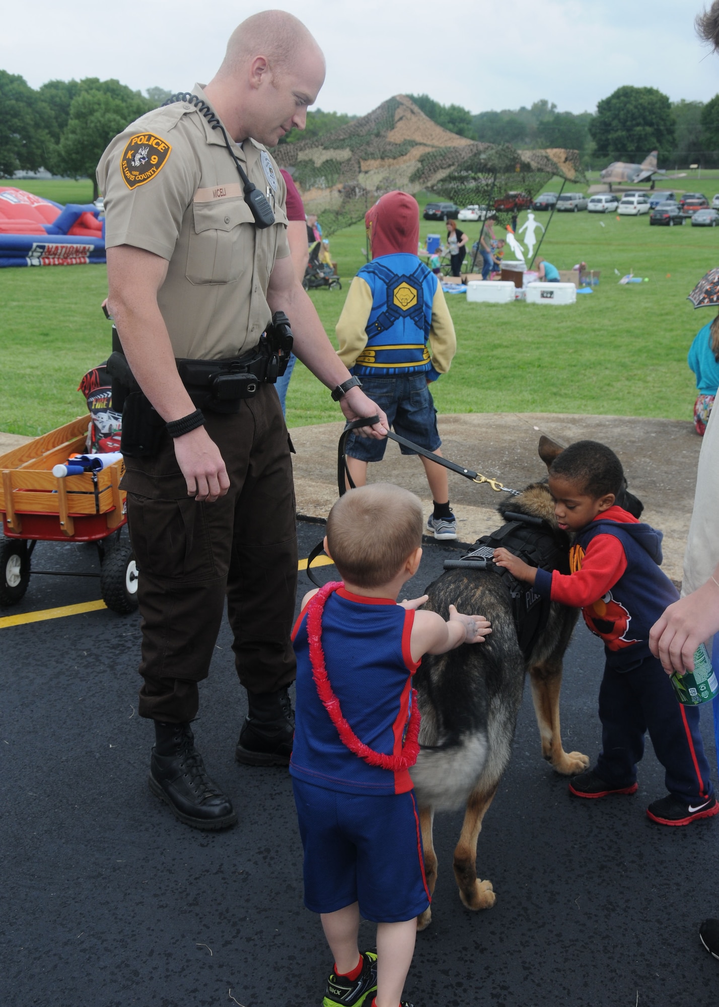 An officer with the St. Louis County Police Department shows off a member of its K-9 unit to children of the 157th Air Operations Group during the Family Day picnic at Jefferson Barracks, Missouri on Sept. 6, 2014. The St. Louis County Police Department has been a regular partner in the Family Day festivities at Jefferson Barracks. (U.S. Air National Guard photo by Senior Airman Nathan Dampf)
