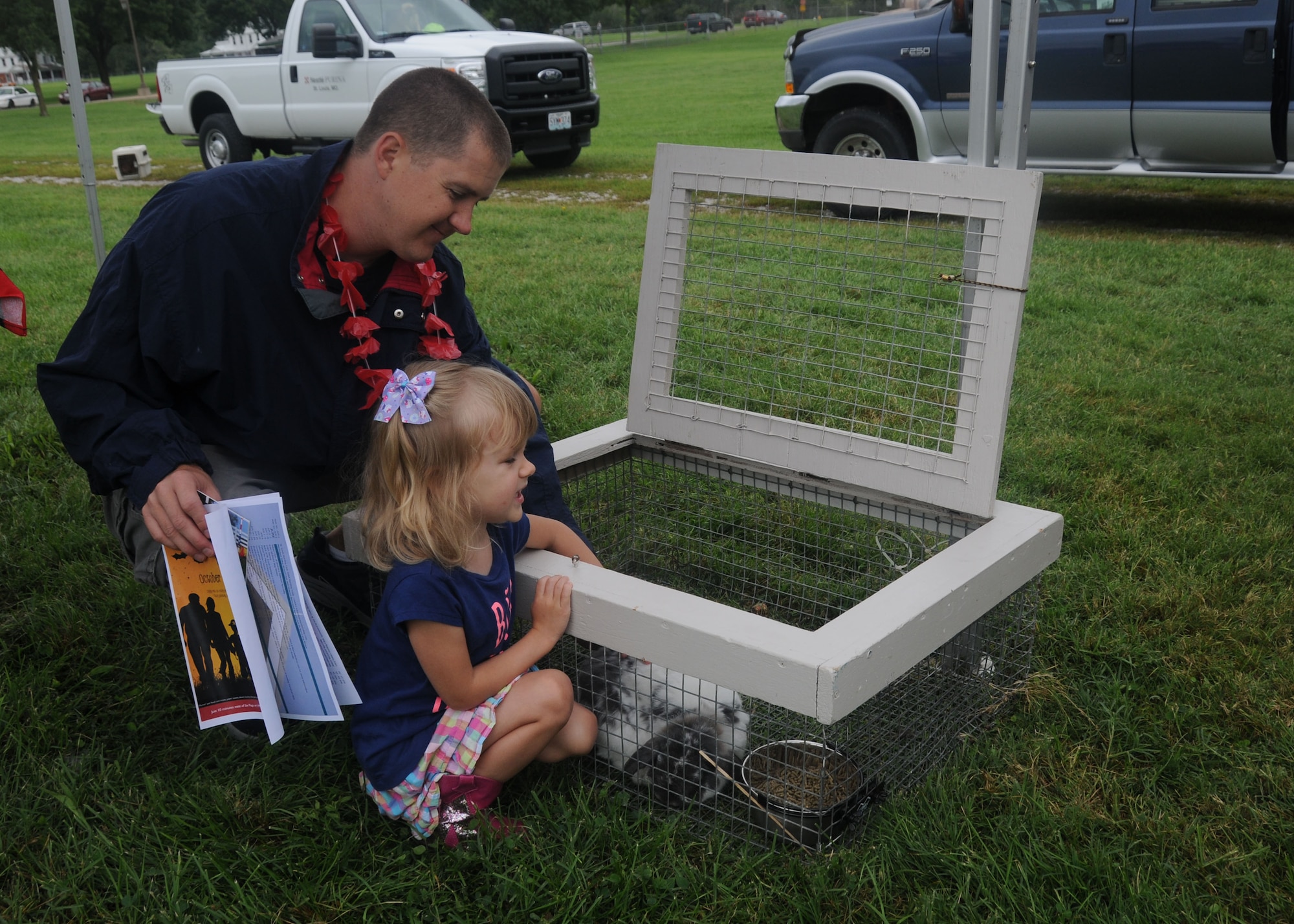 Senior Airman Ben Middleton,157th Air Operations Group, watches his daughter as she participates at the petting zoo organized by Purina Farms during the 2014 Family Picnic at Jefferson Barracks, Missouri on Sept. 6, 2014. Purina Farms also presented a dog show for Citizen Airmen and their Families at the event. (U.S. Air National Guard photo by Senior Airman Nathan Dampf)

