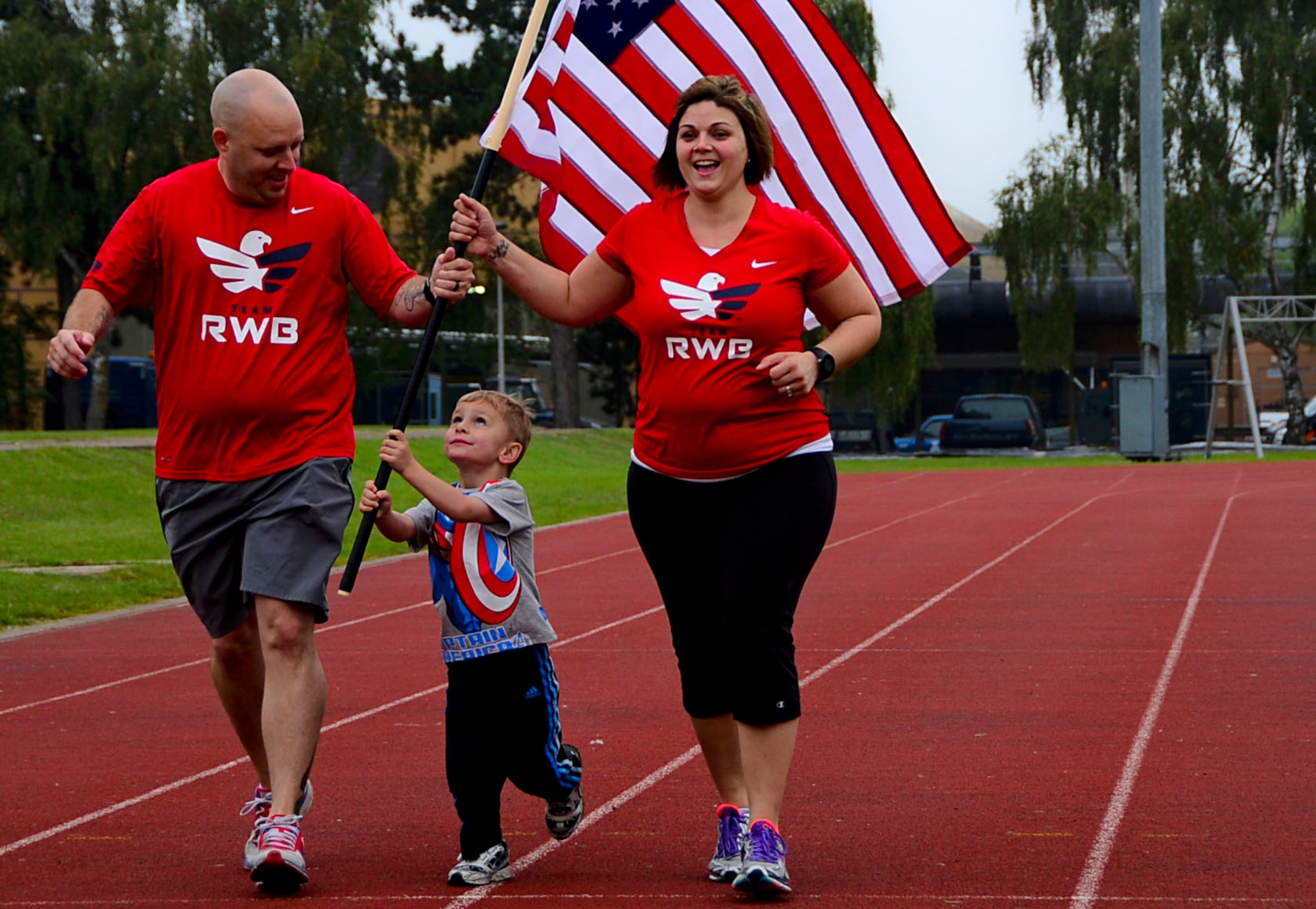 Master Sgt. Jason Aucoin runs with his wife Tech. Sgt. Jennifer Aucoin, during a 9/11 Memorial 5K Run/Walk “Moving Tribute” at Royal Air Force Lakenheath, England, Sept. 11, 2014. Their ‘Team Red, White and Blue’ shirts, represents the partnership between civilians and veterans whose mission is to strengthen and enhance the lives of veterans by connecting them with their local community through various social and physical activities. Master Sgt. Aucoin is the wing ground safety officer for the 48th Fighter Wing Safety Office, and Tech. Sgt. Aucoin is the training manager for the 48th Maintenance Group. (U.S. Air Force photo by Airman 1st Class Erin O’Shea/Released)