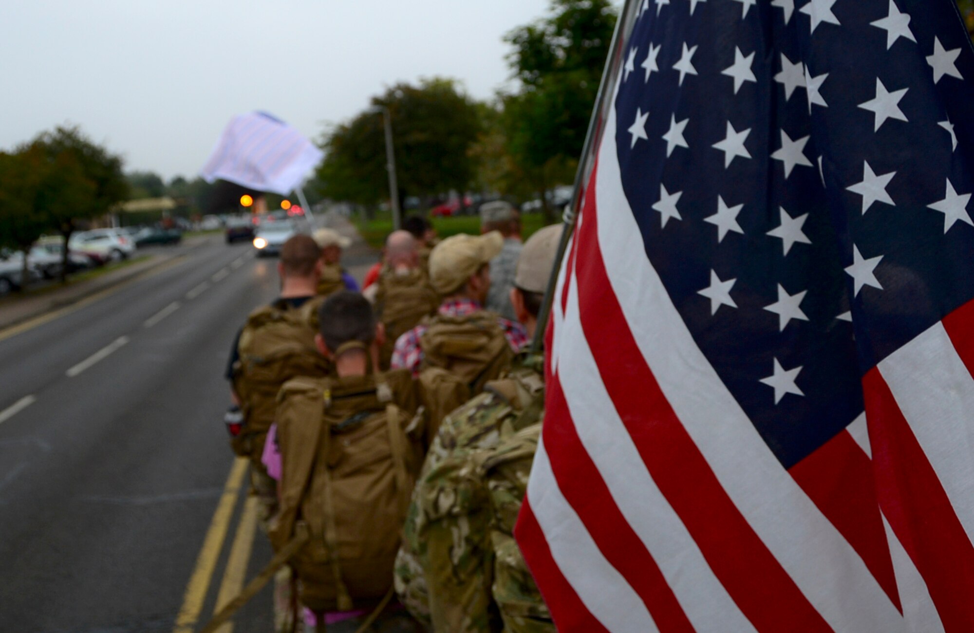 Airmen from the 48th Civil Engineer Squadron Explosive Ordnance Disposal flight, participate in a ruck march during a 9/11 Memorial 5K Run/Walk “Moving Tribute” at Royal Air Force Lakenheath, England, Sept. 11, 2014. Many of the participants ran with American flags to pay respect to those who lost their lives during the tragic events that occurred 13 years ago. (U.S. Air Force photo by Airman 1st Class Erin O’Shea/Released)