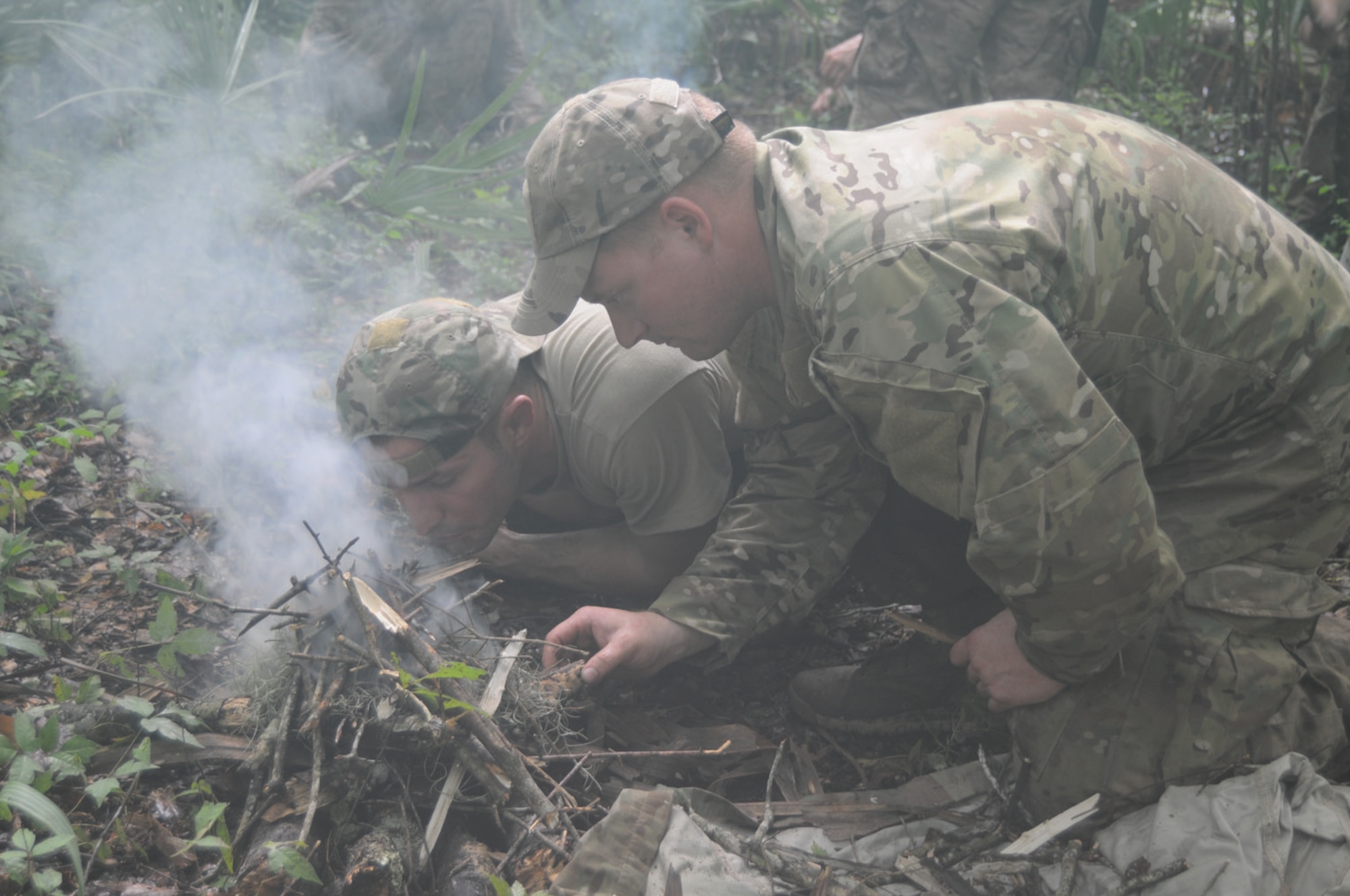 Two students work on their fire during the fire challenge –– a competition to see who can get a knee-high, maintainable fire going first –– during a tropical environment survival exercise in Louisiana's Atchafalaya Basin Aug. 30-Sept. 1. (U.S. Army photo by Jean Dubiel)