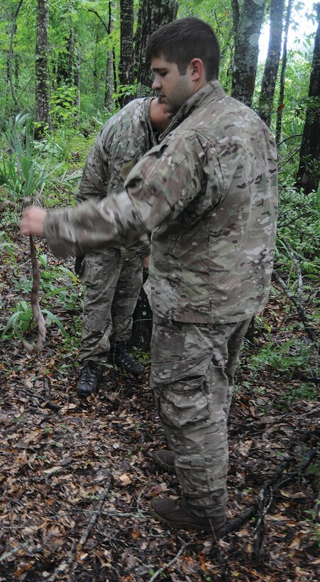 A student holds part of his breakfast –– fresh copperhead snake –– before skinning it in the Atchafalaya Basin in Southern Louisiana during a tropical environment survival exercise held Aug. 30-Sept. 1. (U.S. Army photo by Jean Dubiel)
