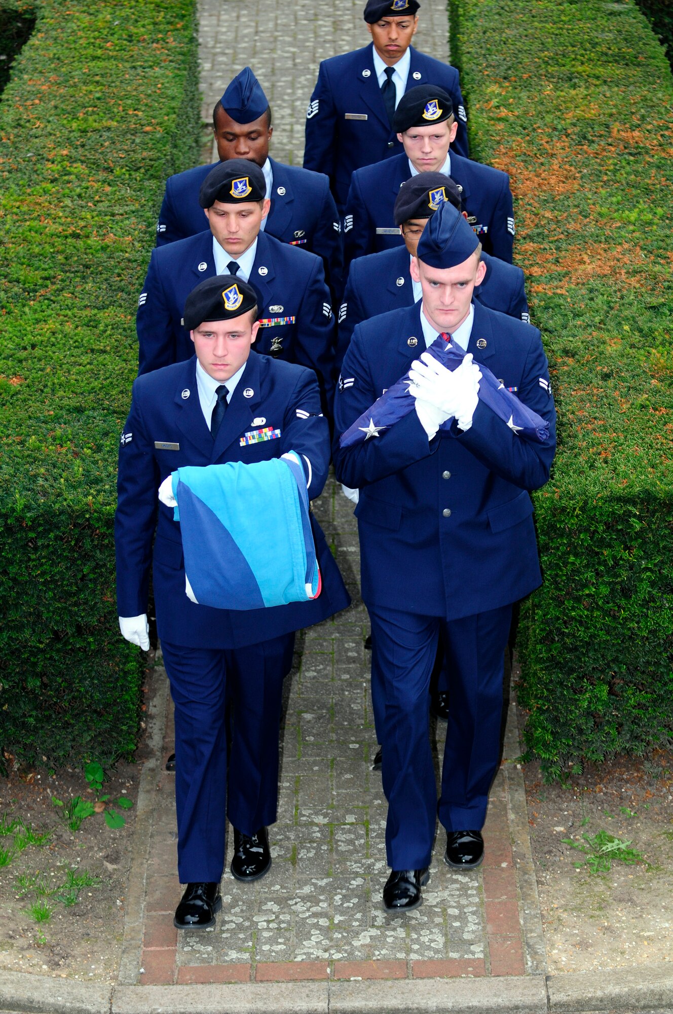 RAF Mildenhall and RAF Lakenheath first responders carry the U.S. flag and Royal Air Force ensign to present to U.S. Air Force Col. Kenneth T. Bibb Jr., 100th Air Refueling Wing commander, during a 9/11 memorial retreat ceremony Sept. 11, 2014, on RAF Mildenhall, England. This year marks the 13th anniversary of the attacks on the World Trade Center in New York City. (U.S. Air Force photo/Karen Abeyasekere/Released)