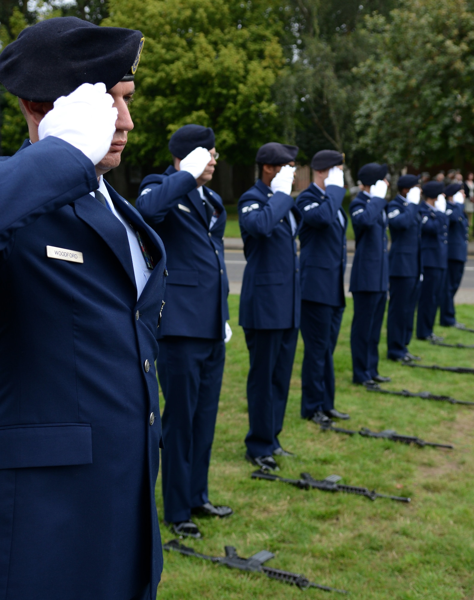 A firing detail salutes the U.S. flag as it’s lowered during a 9/11 memorial retreat ceremony Sept. 11, 2014, on RAF Mildenhall, England. This year marks the 13th anniversary of the attacks on the World Trade Center in New York City. (U.S. Air Force photo/Airman 1st Class Dillon Johnston/Released)
